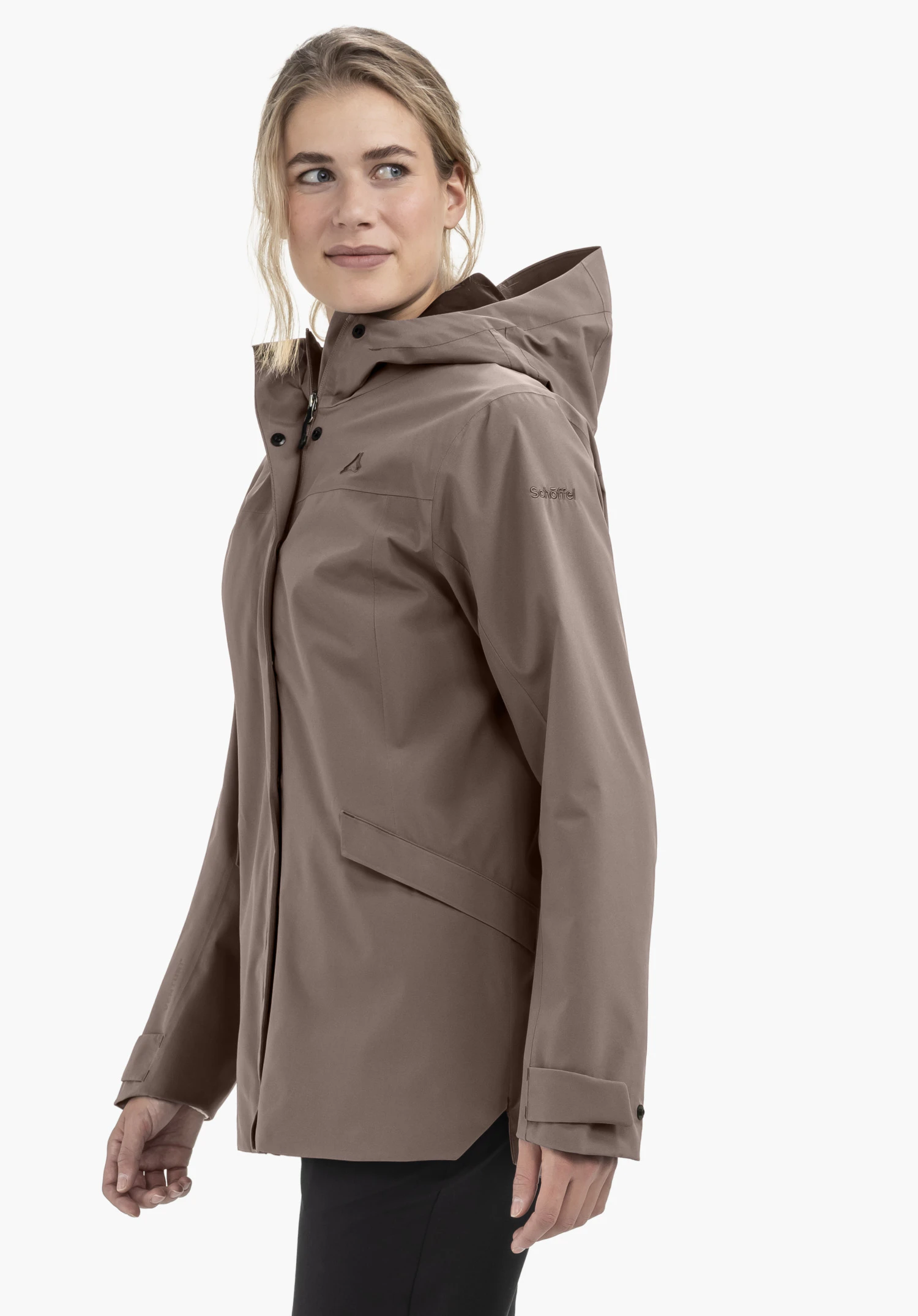 CIRC Jacket Style Smue WMN in brown. The model is positioned in a semi-profile pose against a neutral background. The focus is on the jacket, with the subtle Schöffel logo clearly visible on the upper arm.