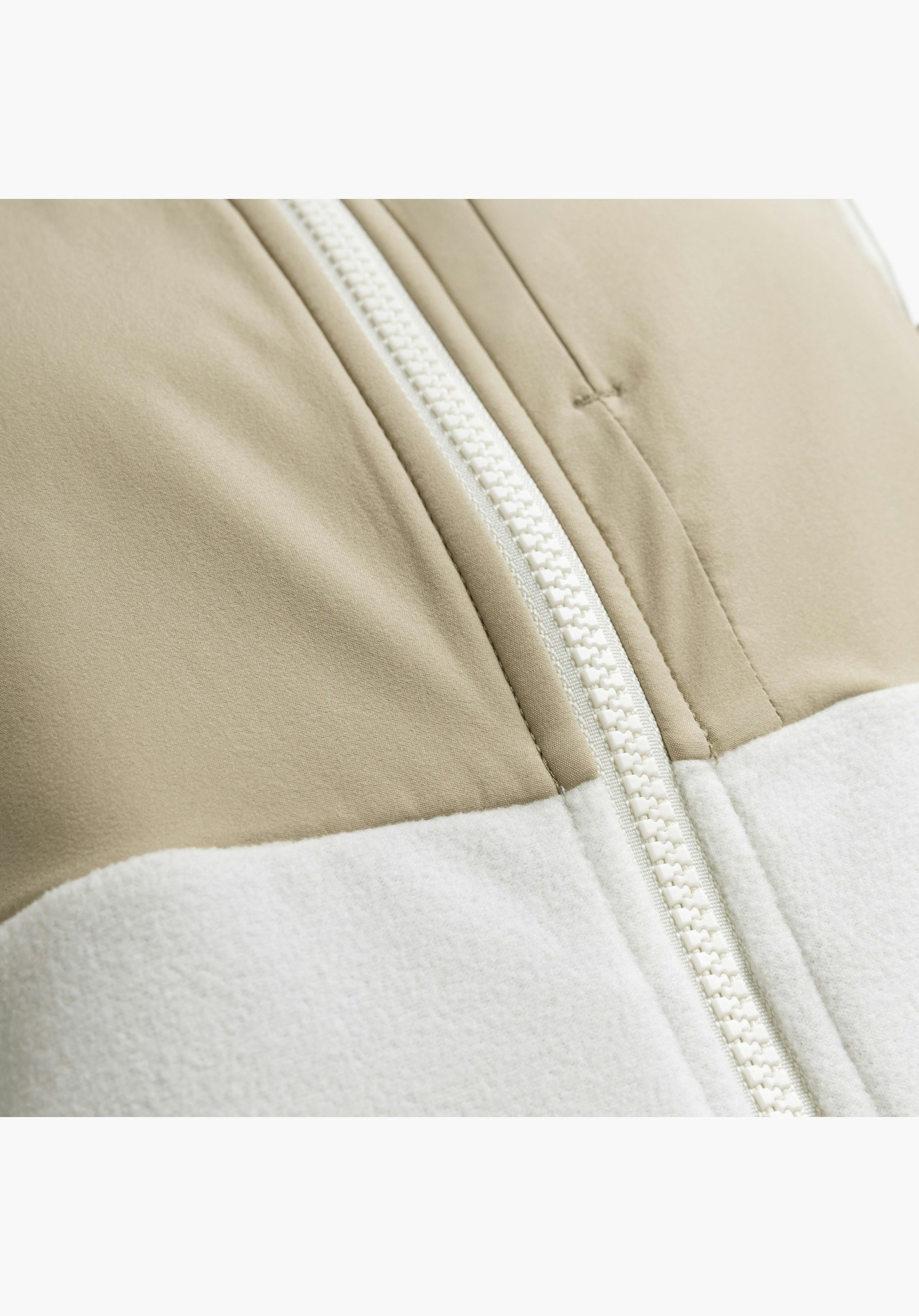 Fleece Vt Style Ash WMN präsentiert den markanten Reißverschluss und den textilen Kontrast aus glattem Stoff und flauschigem Fleece in der Farbe Natur als Nahaufnahme vor neutralem Hintergrund.