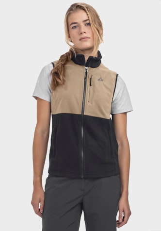 Fleece Vt Style Ash WMN on a model standing frontally. The gilet features a colour-block design with the lower section in black and a visible Schöffel logo on the left chest. It is worn over a light t-shirt and presented against a neutral background.