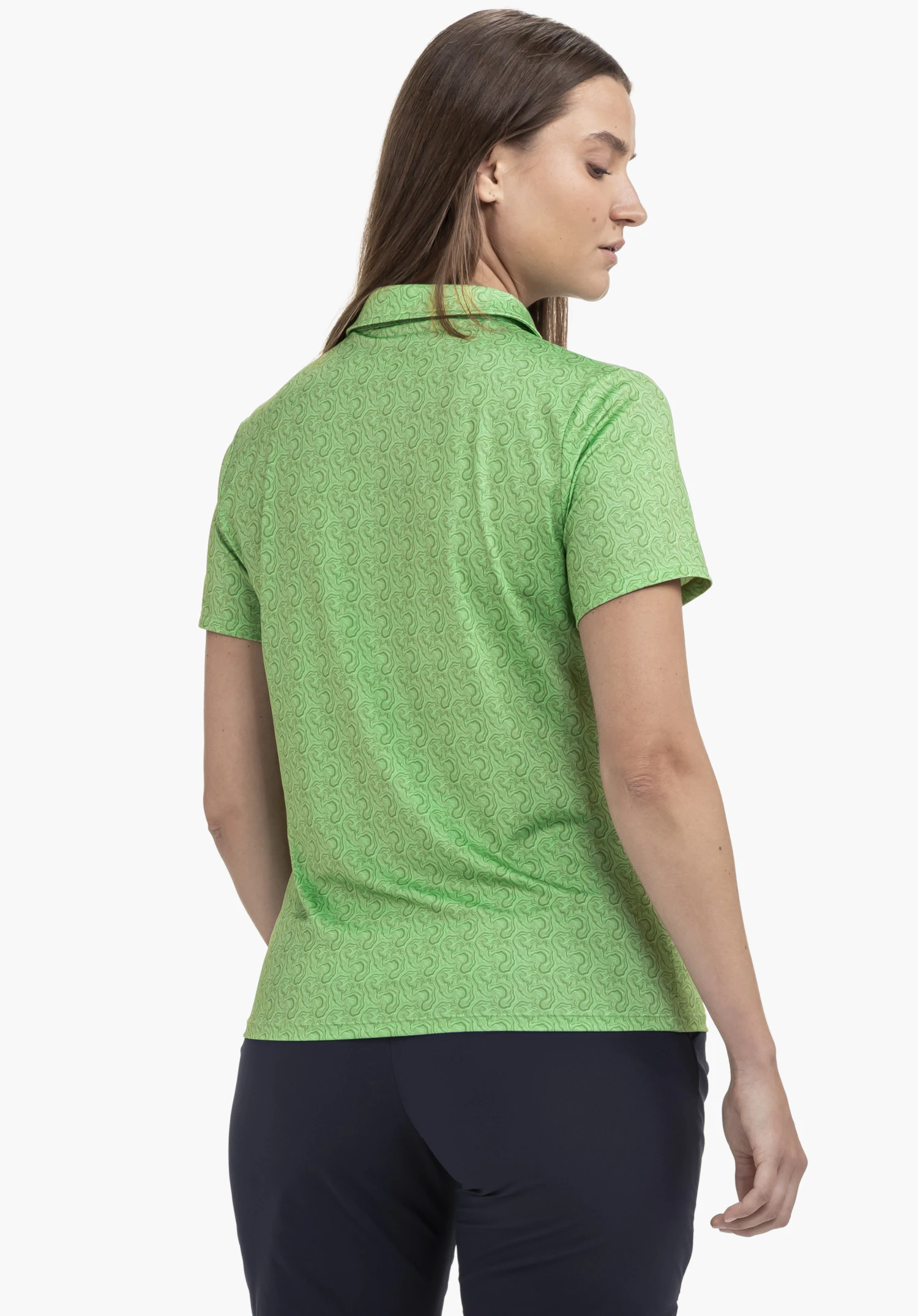 Polo Shirt Style Fraydo WMN in Grün mit dezentem Allover-Muster, getragen von einem Model in der Rückenansicht mit Blick zur Seite.