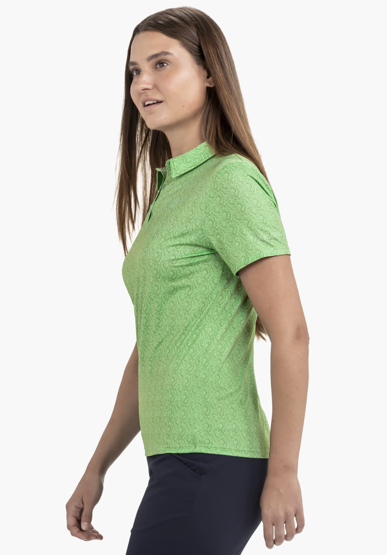 Polo Shirt Style Fraydo WMN in Grün zeigt eine lächelnde Frau in Seitenansicht vor einem neutralen Hintergrund. Das Polo präsentiert sich mit einer strukturierten Oberfläche, einem klassischen Kragen und einem dezenten Schöffel-Logo am Saum.