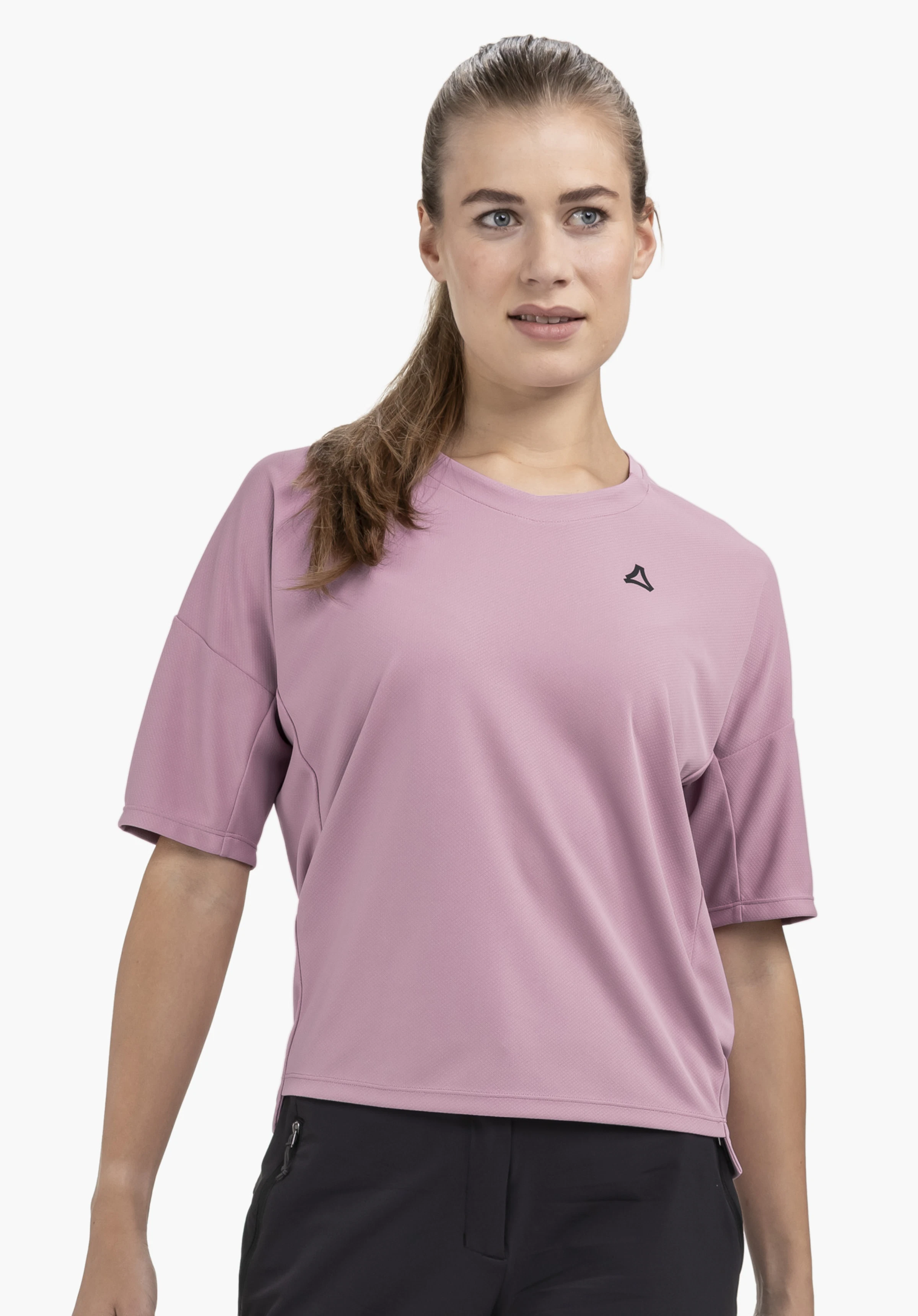 T Shirt Style Enixa WMN an einem Model. Das rosafarbene Shirt zeigt das Schöffel-Logo auf der linken Brust. Das Model steht frontal vor einem neutralen Hintergrund.