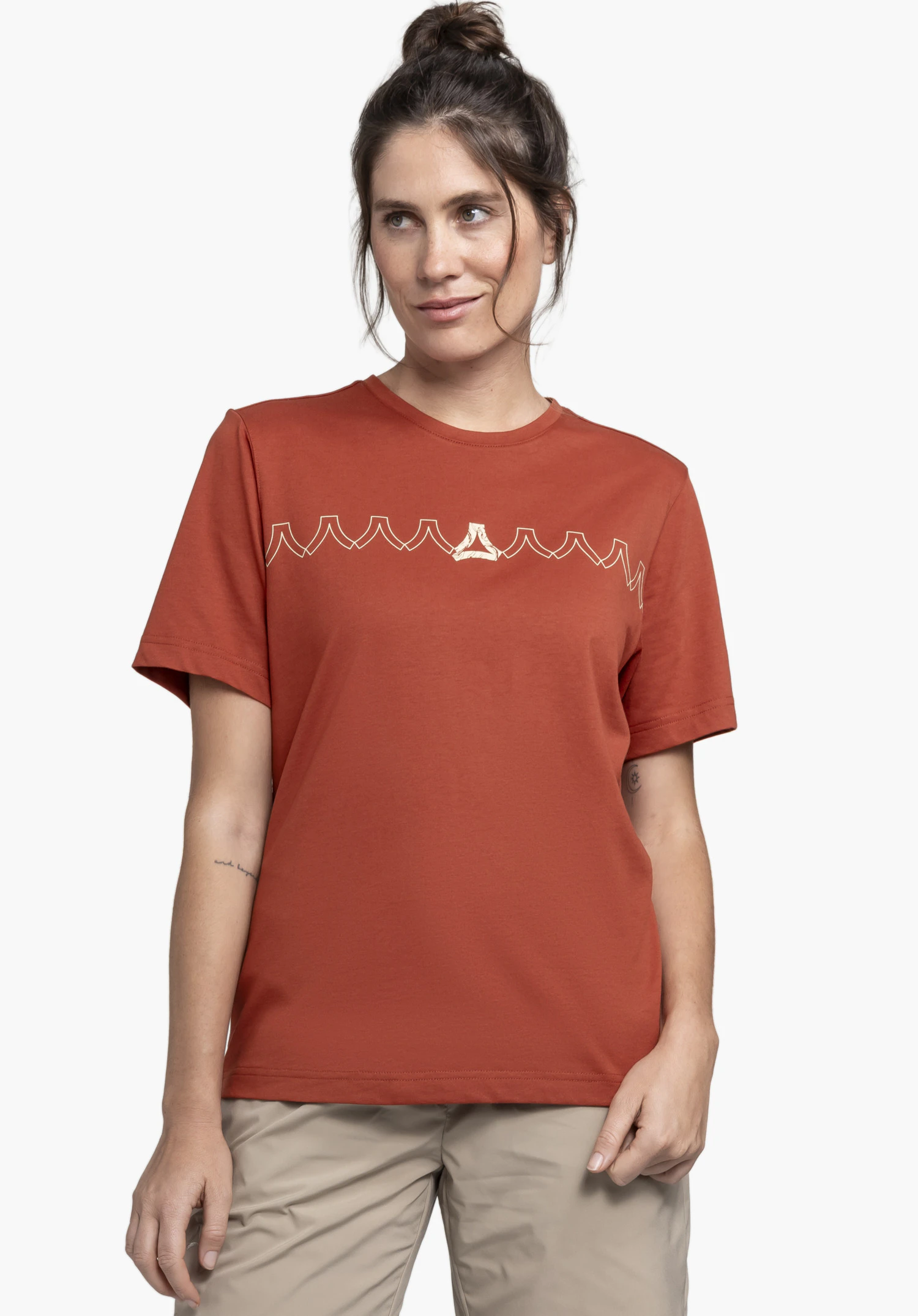 T Shirt Style Elmori WMN en rouge, porté par un mannequin se tenant de face et regardant sur le côté, devant un fond neutre.