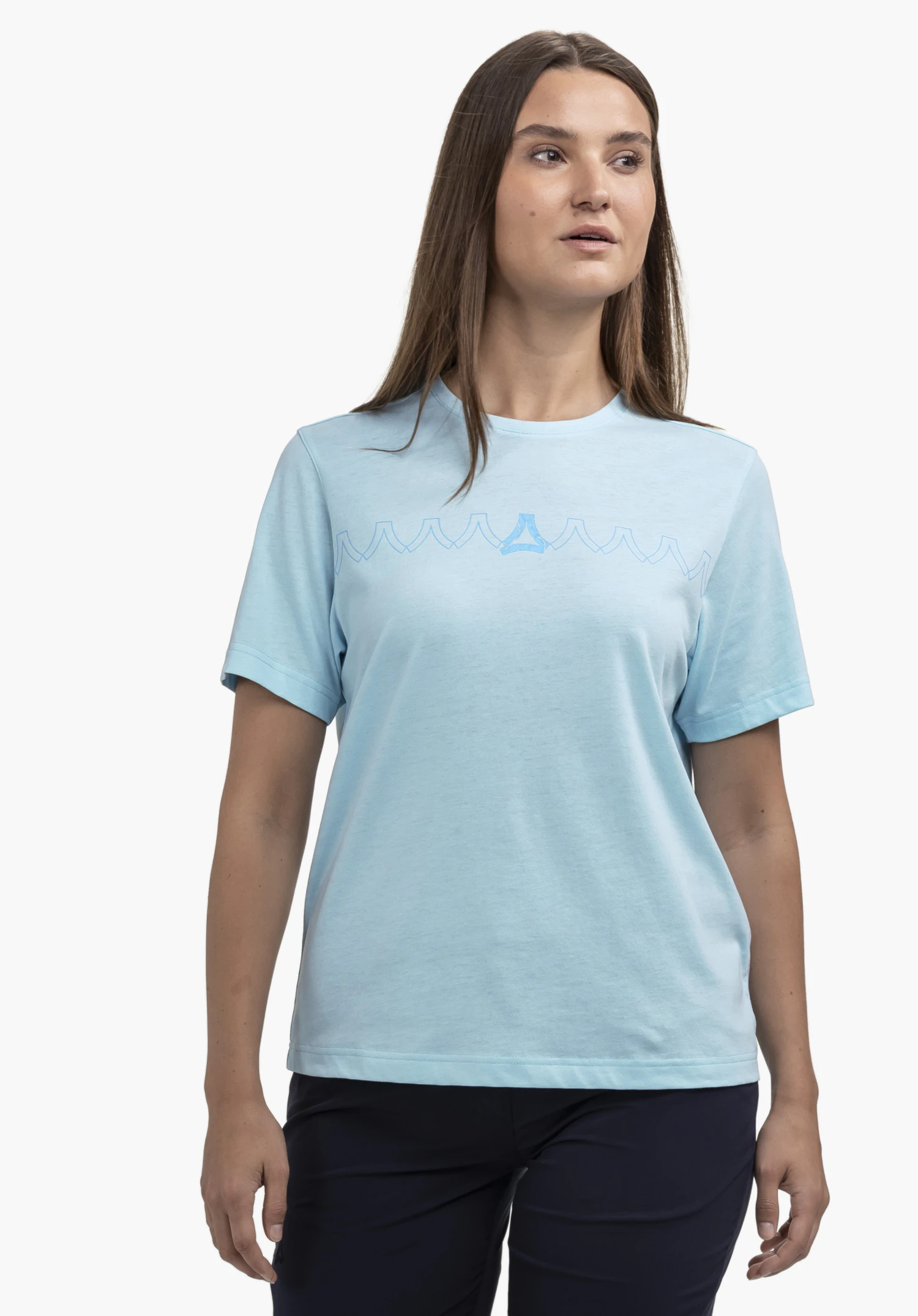 T Shirt Style Elmori WMN en bleu, porté par un mannequin. Le mannequin se tient de face pour présenter l'avant du t-shirt, qui présente un motif de lignes graphiques et un Schöffel-Logo intégré sur la poitrine, photographié sur un fond neutre.