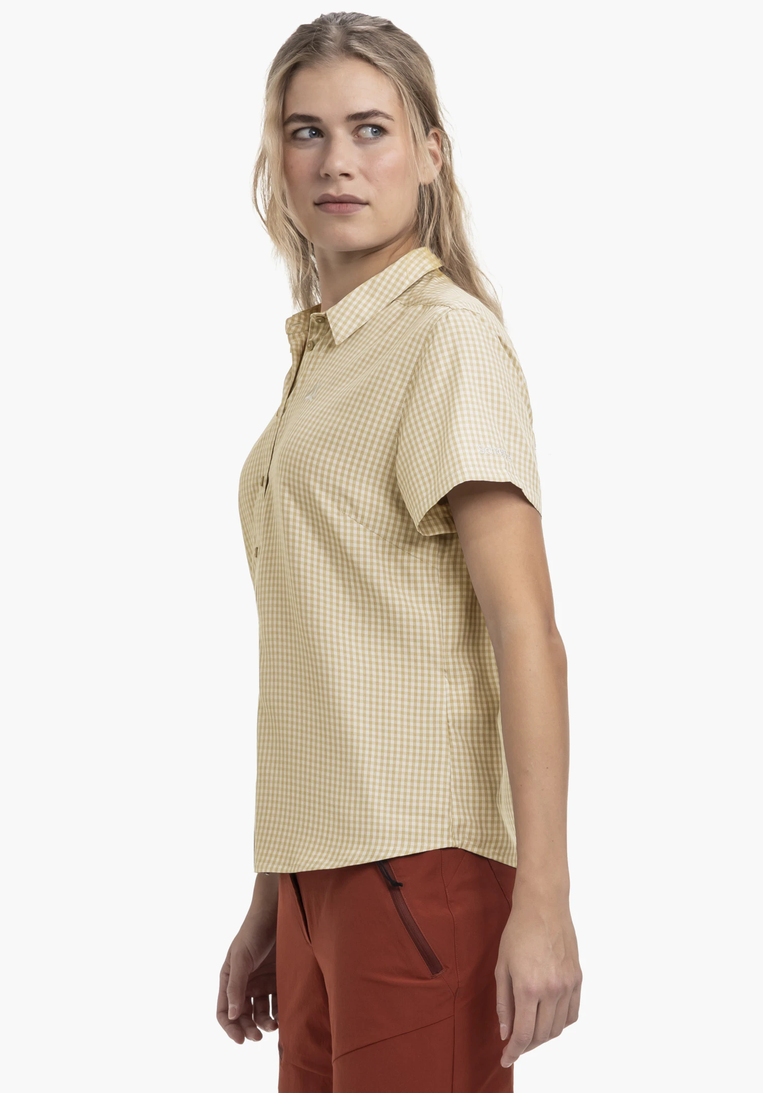 CIRC Blouse Style Dalfoss WMN. Un mannequin se tient de profil devant un fond neutre et porte le chemisier à manches courtes à carreaux de couleur natur. Le logo blanc Schöffel est visible sur la manche gauche.