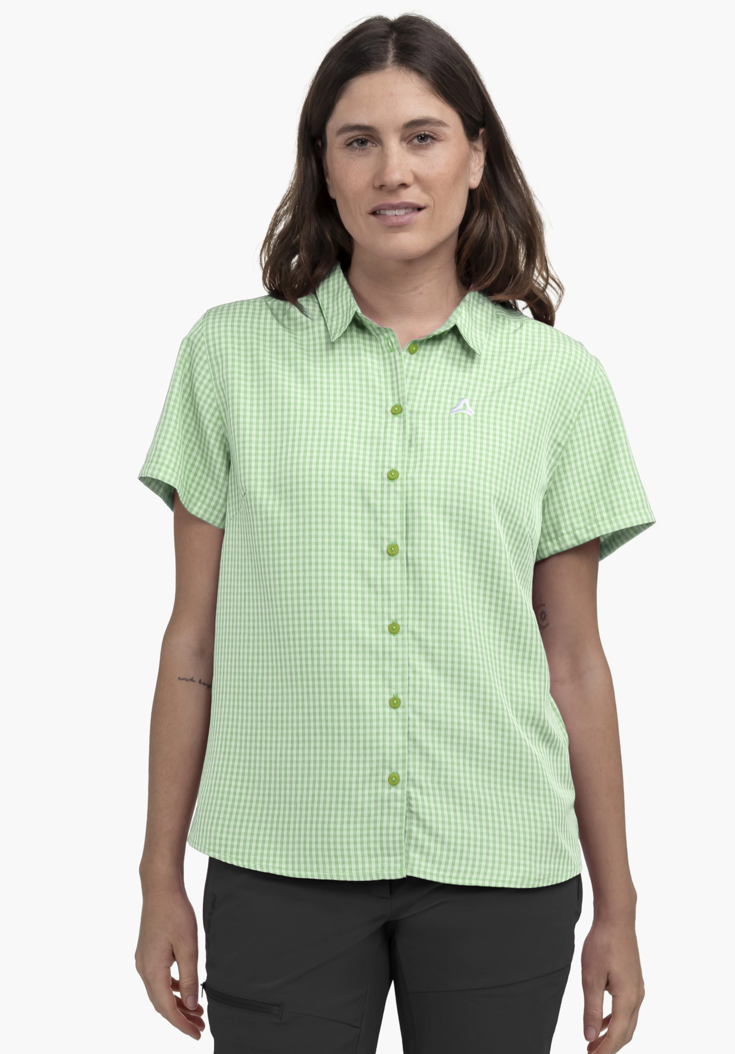 CIRC Blouse Style Dalfoss WMN sur un mannequin qui se tient de face et porte le chemisier à manches courtes à carreaux verts. Le logo Schöffel est visible sur le côté gauche de la poitrine. La photo montre le vêtement porté sur un fond neutre.