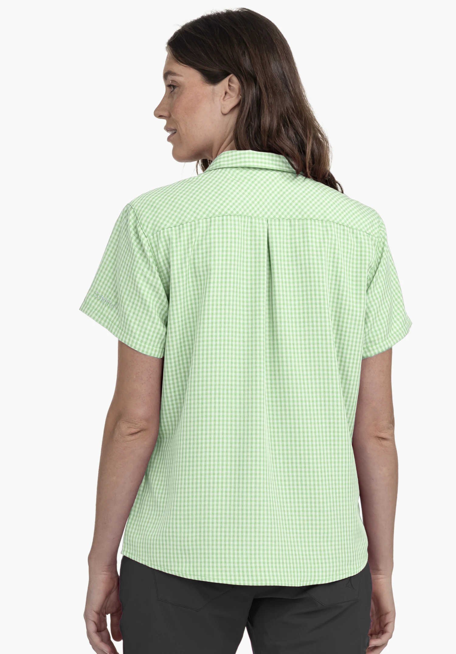 CIRC Blouse Style Dalfoss WMN en vert. Le chemisier est présenté de dos, le mannequin tournant légèrement la tête sur le côté. Le logo Schöffel discret est visible sur la manche. La prise de vue est réalisée sur un fond neutre.