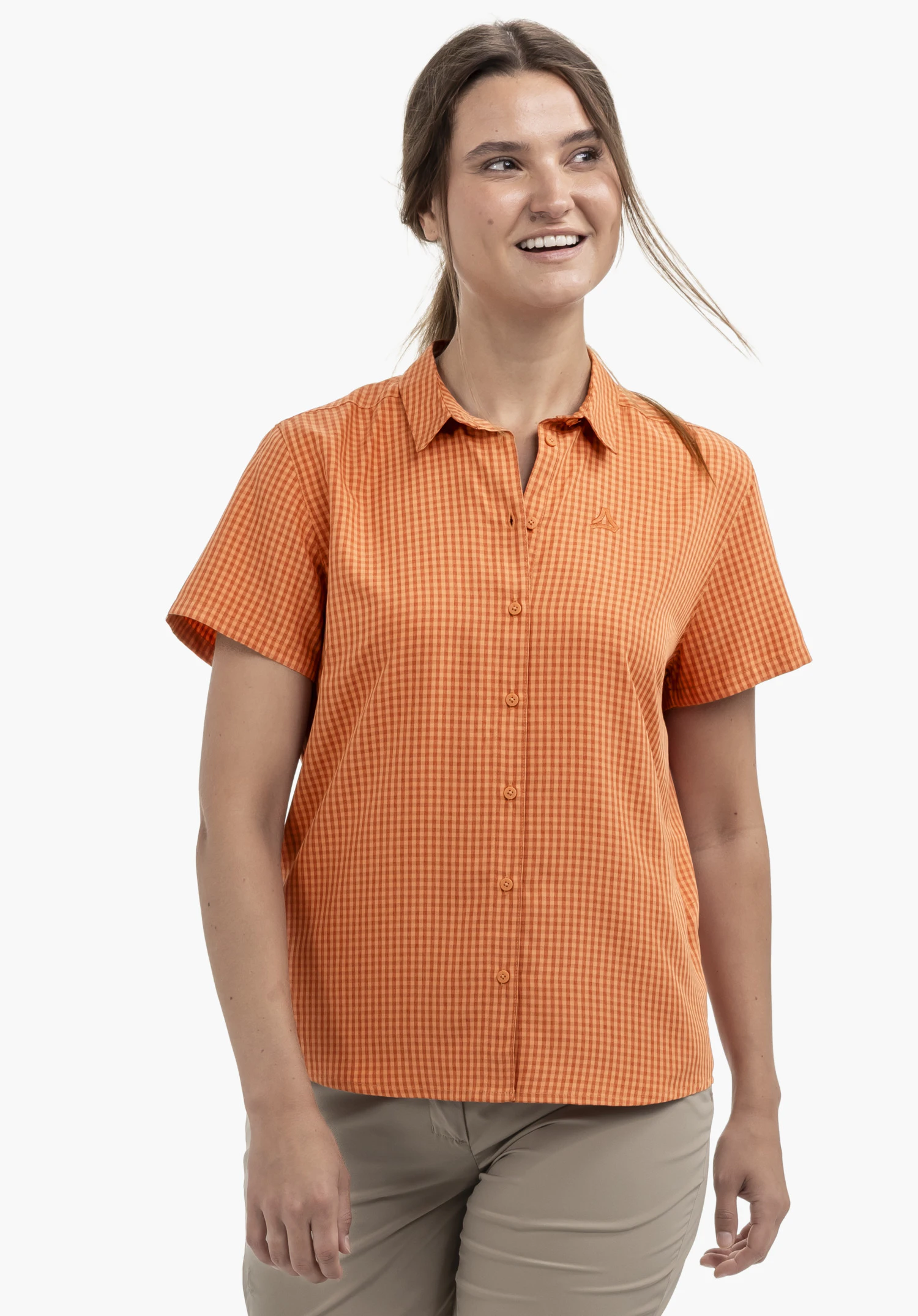 CIRC Blouse Style Dalfoss WMN portée par un modèle. Un modèle se tient de face et présente la chemise à manches courtes à carreaux orange avec le logo Schöffel visible sur la poitrine devant un fond neutre.