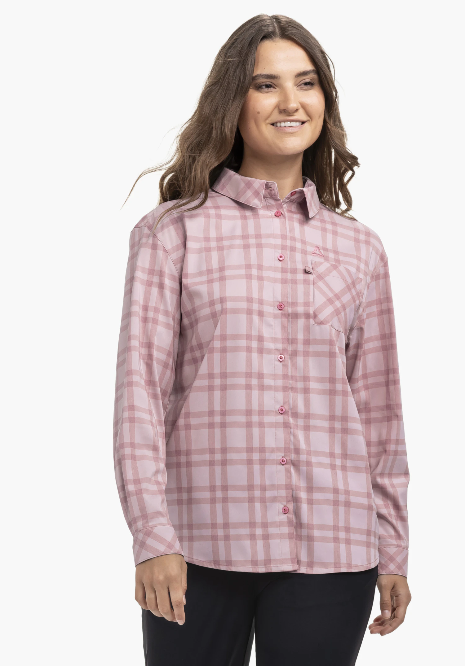 Blouse Style Fraris WMN getragen von einem Model, das in leicht frontaler Pose steht und lächelt. Man sieht eine rosa karierte Langarmbluse mit dem Schöffel-Logo auf der linken Brust, präsentiert vor einem neutralen Hintergrund.