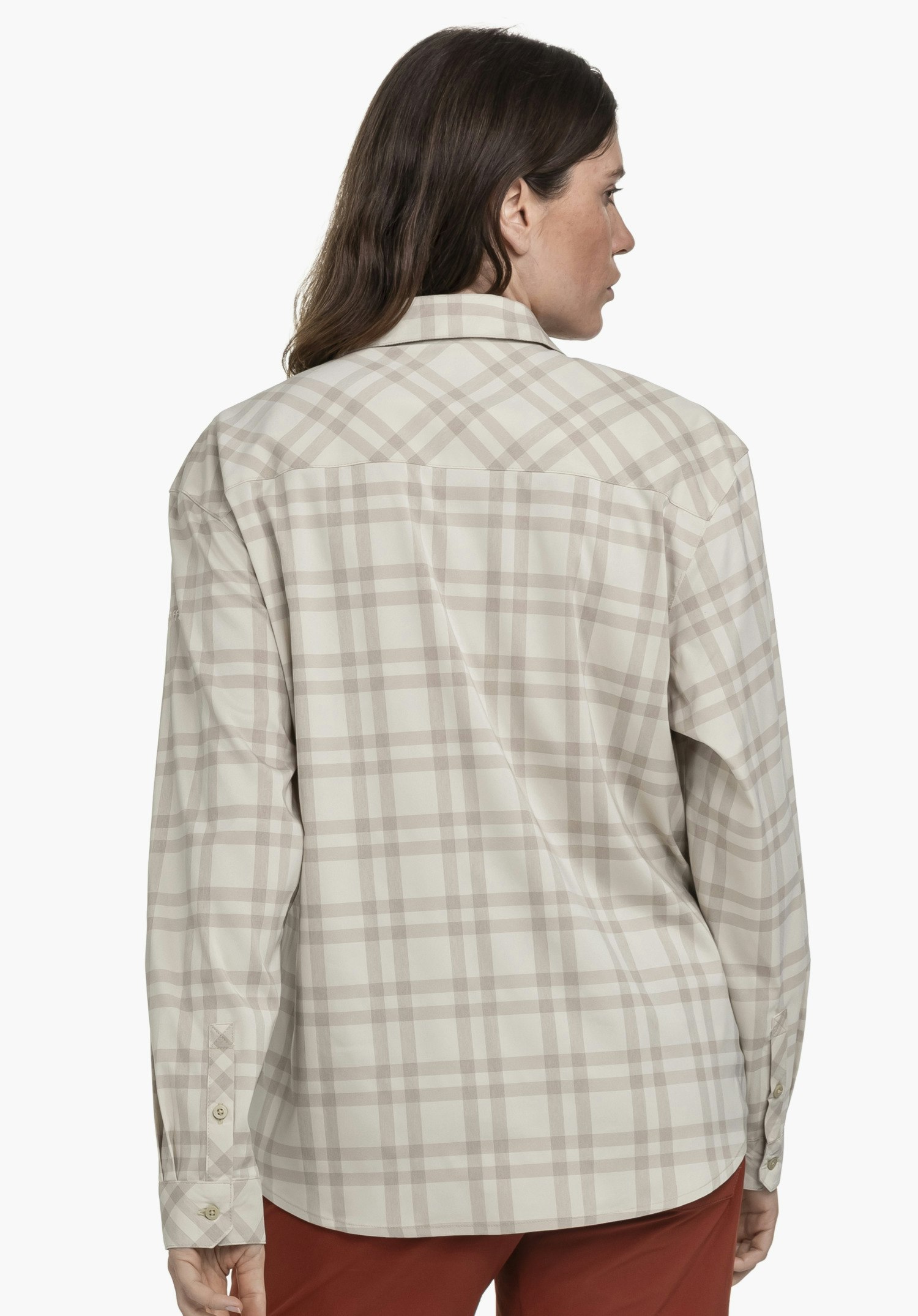 Blouse Style Fraris WMN en beige présentée de dos, devant un fond neutre. La blouse offre une coupe décontractée et arbore le logo Schöffel discret sur la manche.