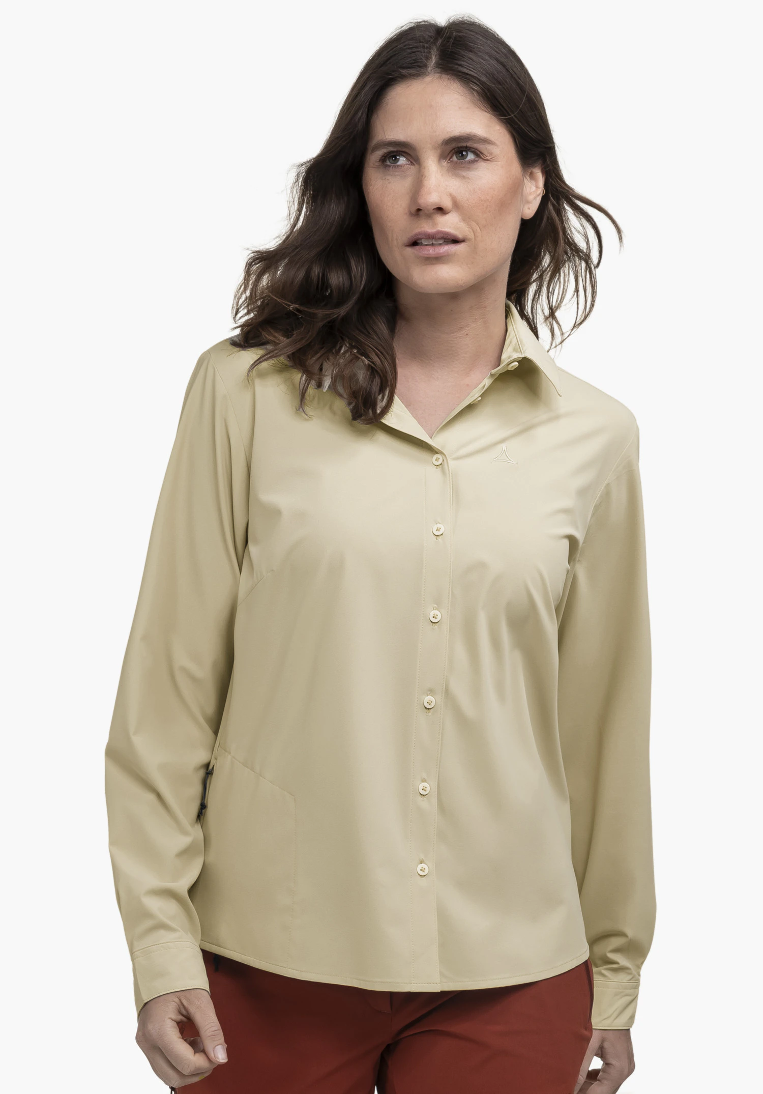Blouse Style Dunajec WMN. Un mannequin porte le chemisier beige sur lequel le logo Schöffel est visible sur la poitrine gauche. Elle se tient de face devant un fond neutre.