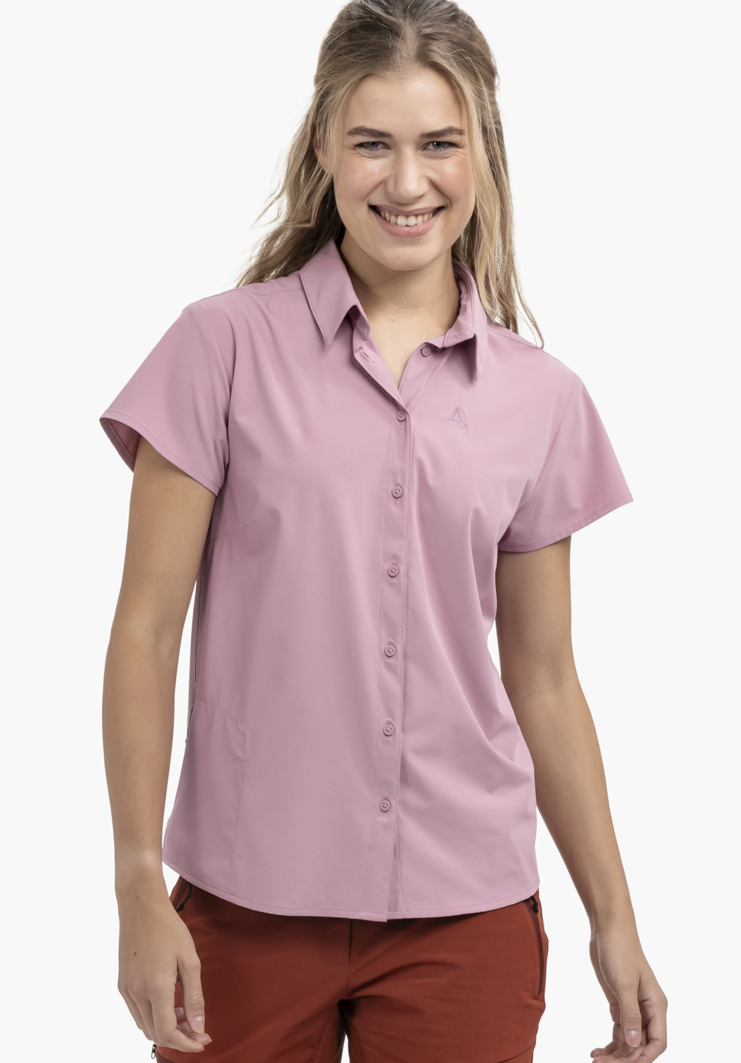 Blouse Style Dooser WMN gedragen door een model dat frontaal staat en glimlacht. Je ziet de blouse met korte mouwen in de kleur roze met een subtiel Schöffel-logo op de linkerborst, gefotografeerd tegen een neutrale achtergrond.