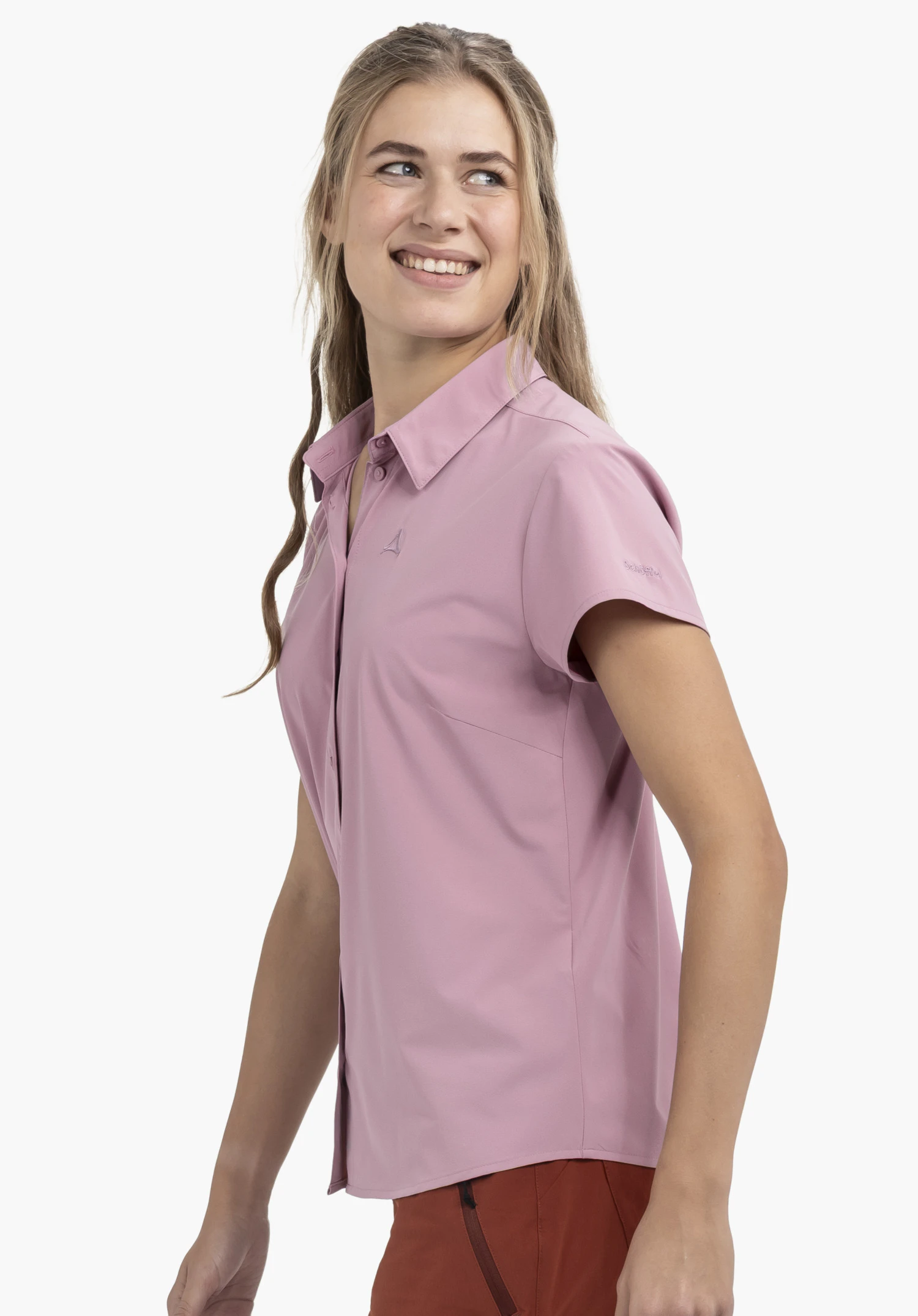 Blouse Style Dooser WMN in de kleur roze, gedragen door een glimlachend model in zijaanzicht tegen een neutrale achtergrond, waarbij het subtiele Schöffel-logo op de mouw zichtbaar is.