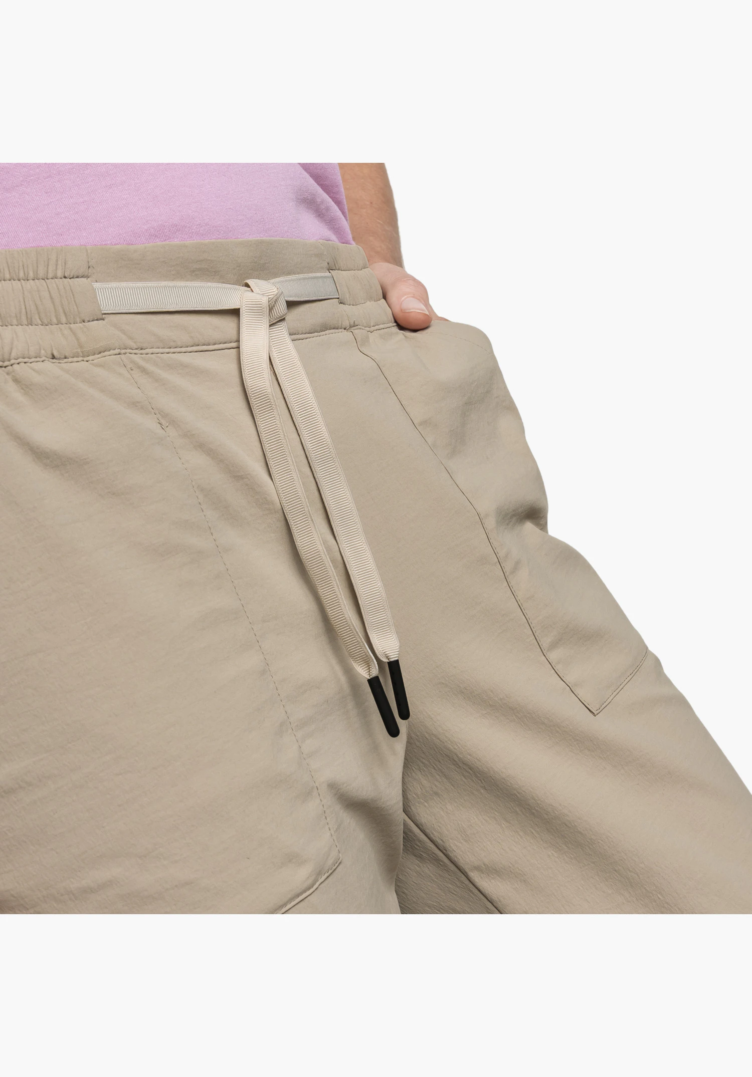 Pants Rangun L focusing on the elasticated waistband in beige and the flat drawcord with black tips at the pocket opening, close-up against a white/neutral background.