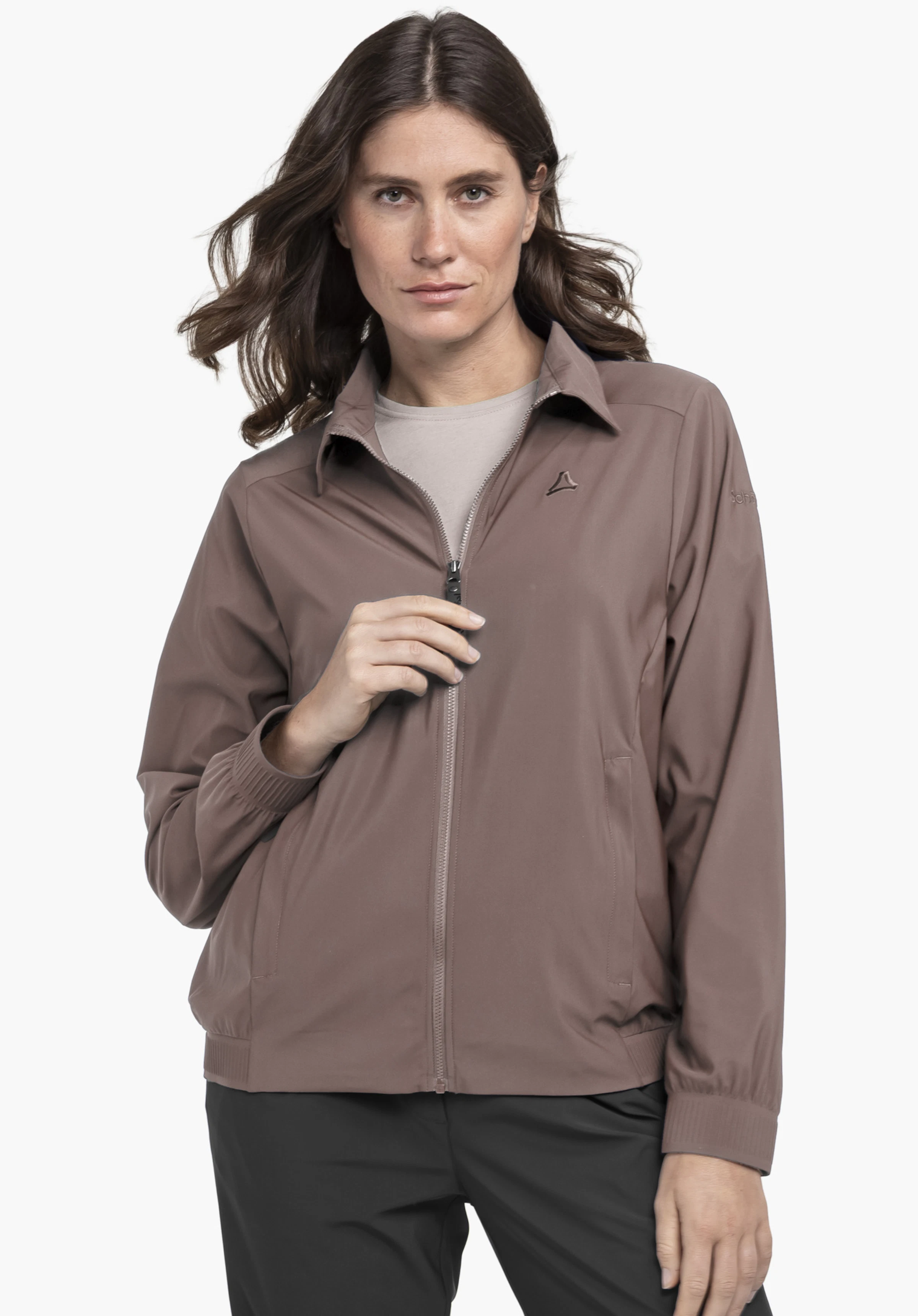 Jersey Jk Style Calmay WMN : Le modèle présente la veste en marron sur un fond neutre. Cette vue de face montre le modèle avec la fermeture éclair fermée, mettant en avant le logo Schöffel discret sur la poitrine.