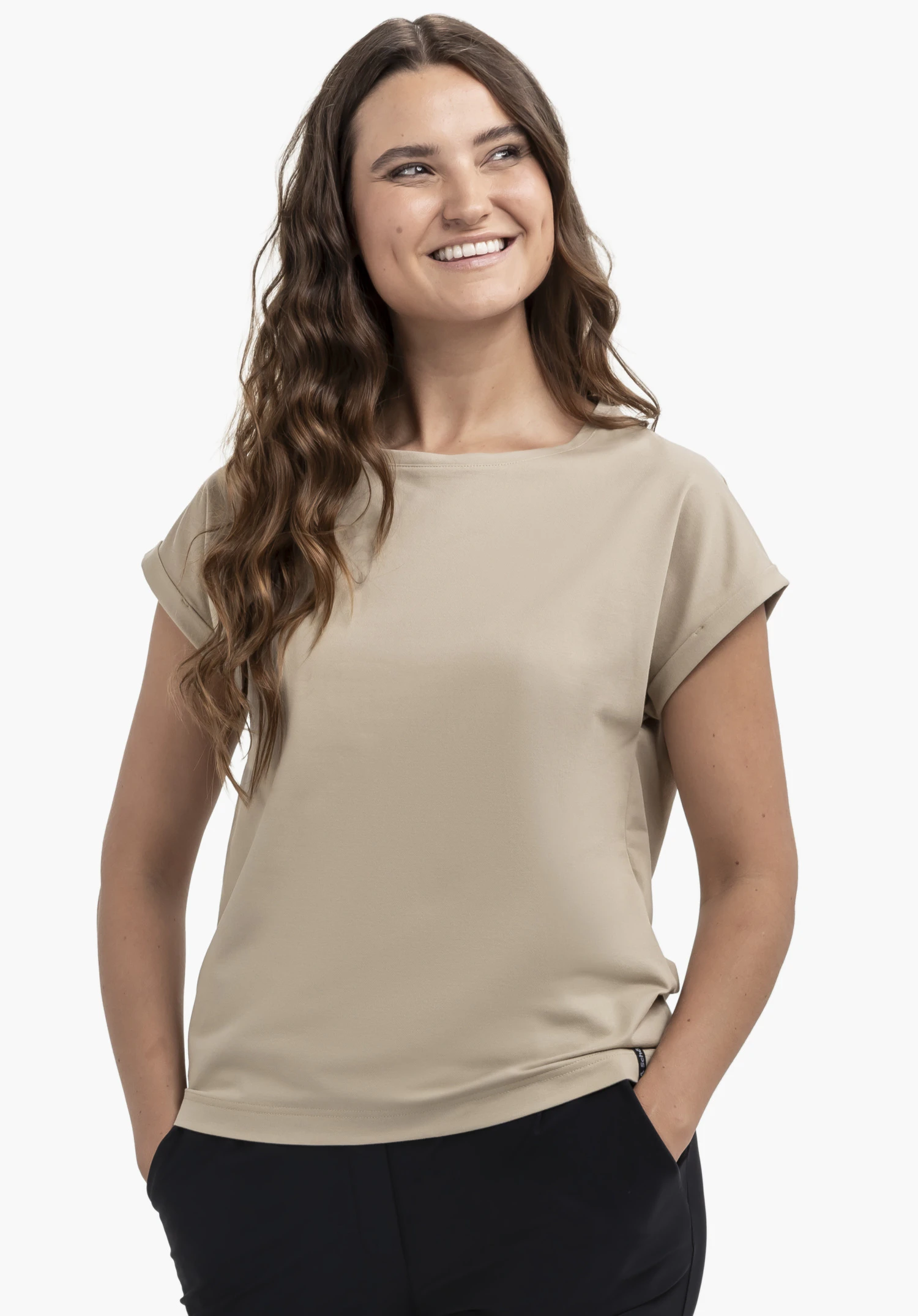 T Shirt Style Serenio WMN in a sophisticated beige, showcased by a smiling model against a neutral background. The shirt features a comfortable fit and rolled-up sleeves, while the subtle Schöffel logo on the bottom hem highlights the signature brand quality.