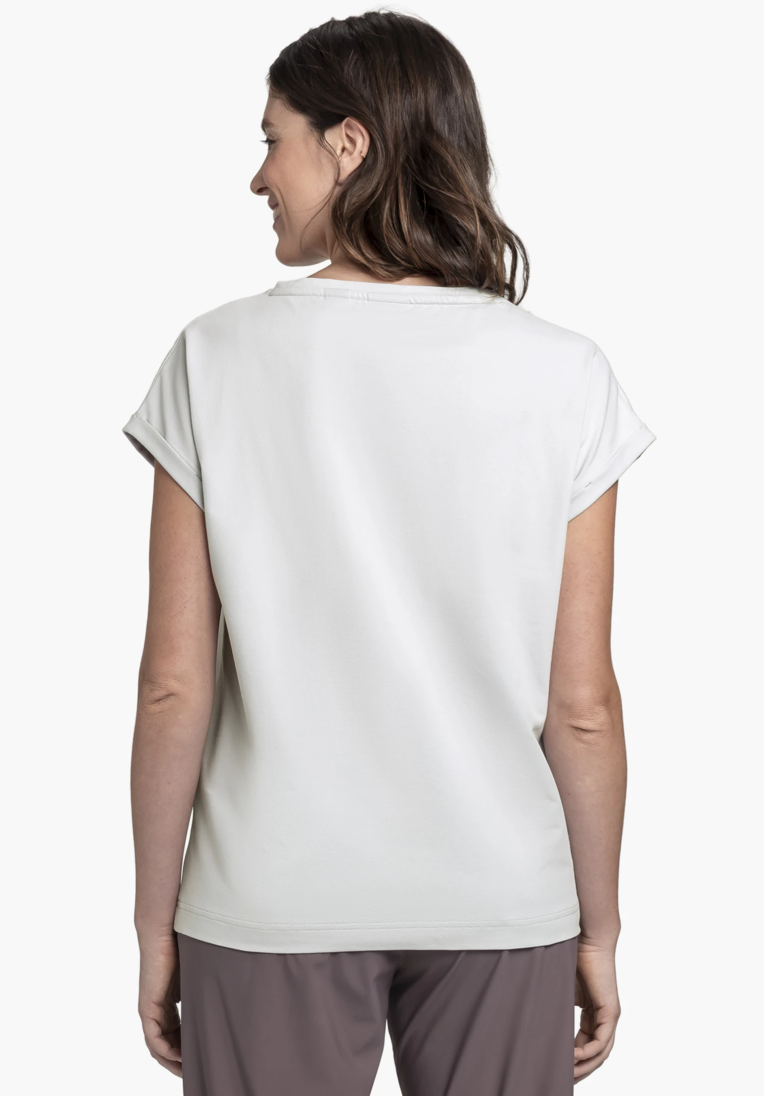 T Shirt Style Serenio WMN en gris, présenté avec une vue de dos. Le mannequin se tient devant un arrière-plan neutre et regarde légèrement sur le côté, mettant en valeur la coupe minimaliste du t-shirt.
