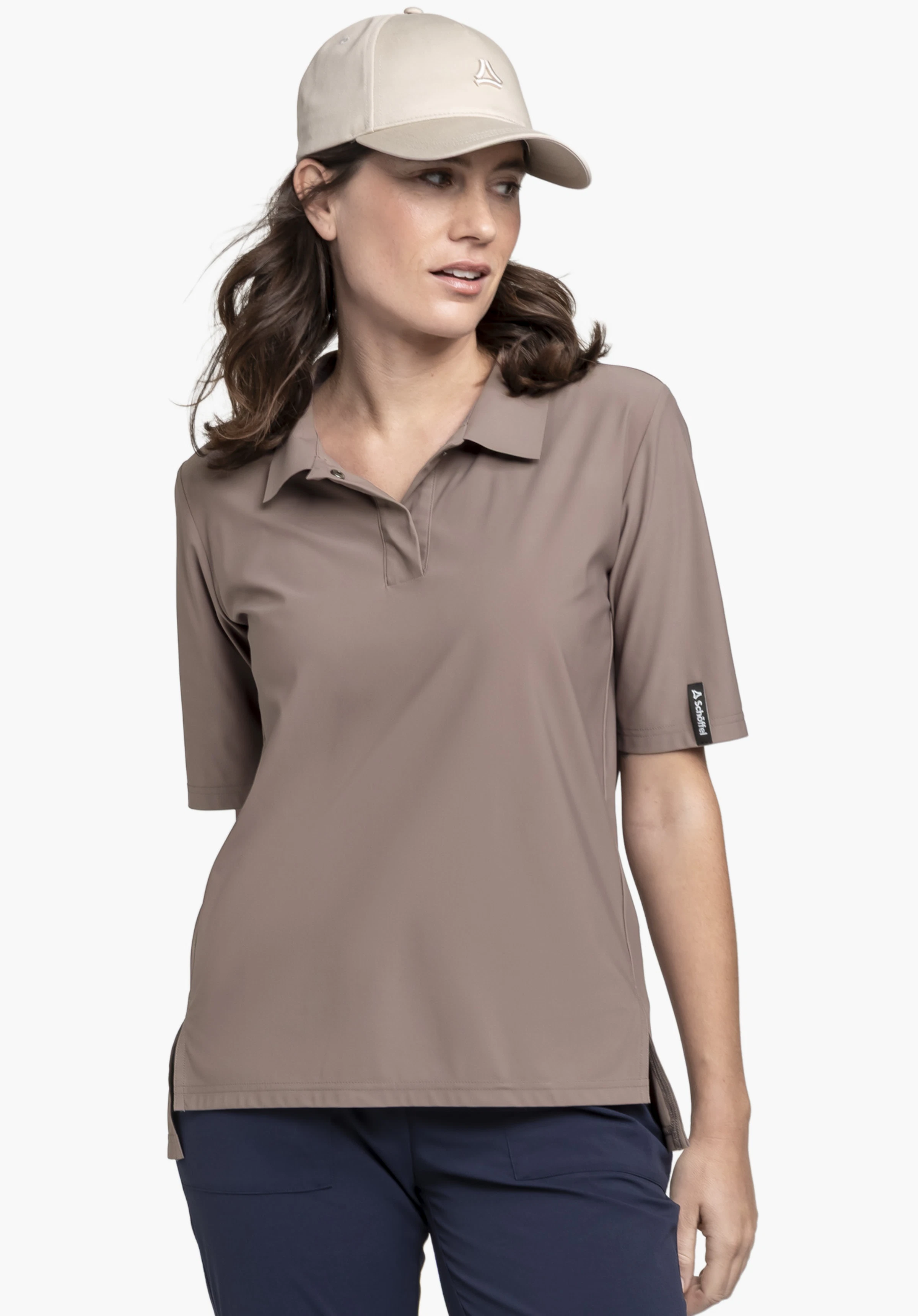 Jersey Polo Style Calmay WMN in the colour brown, worn by a model. The model is standing slightly to the side and looking away, with the Schöffel logo clearly visible on the left sleeve hem, photographed against a neutral background.