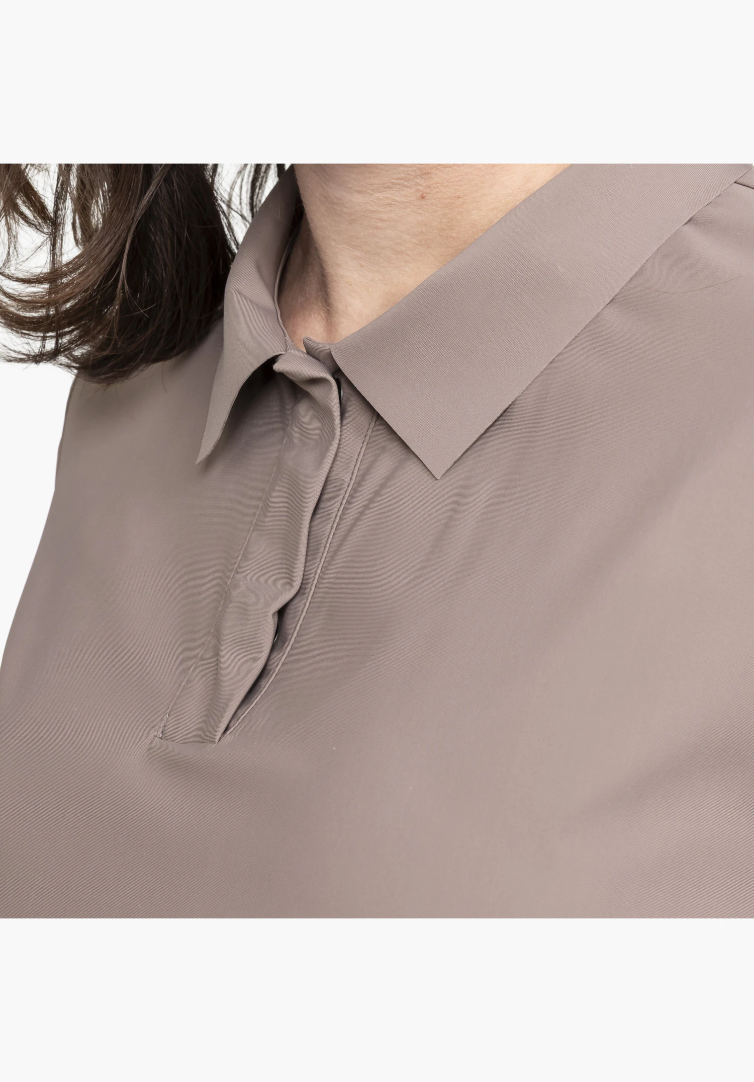Jersey Polo Style Calmay WMN displays the classic collar and the elegant, concealed button placket made of smooth, brown fabric. Close-up against a white/neutral background.