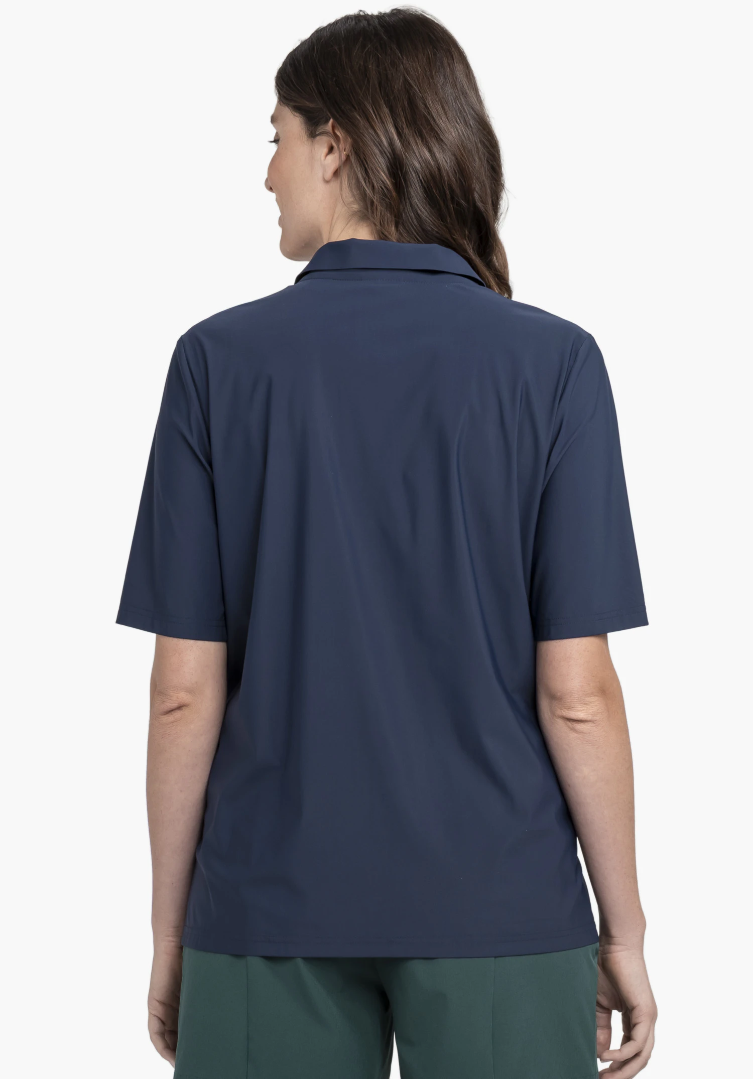 Jersey Polo Style Calmay WMN in Blau präsentiert vor einem neutralen Hintergrund in der Rückenansicht. Das Model zeigt den modernen Schnitt des Poloshirts, wobei der Kragen und das dezente Schöffel-Logo im Nackenbereich gut erkennbar sind.