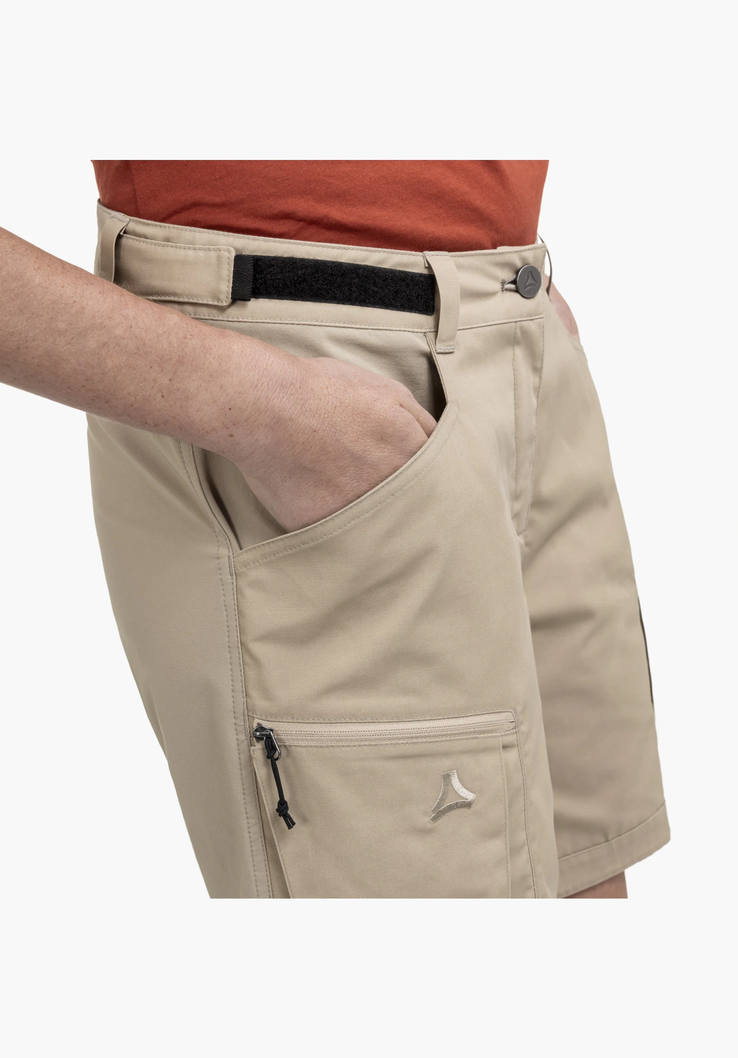 Shorts Style Maghera WMN montre la taille ajustable avec bande Velcro et la poche beige sur la cuisse avec fermeture éclair et le logo Schöffel brodé, gros plan sur fond blanc/neutre.