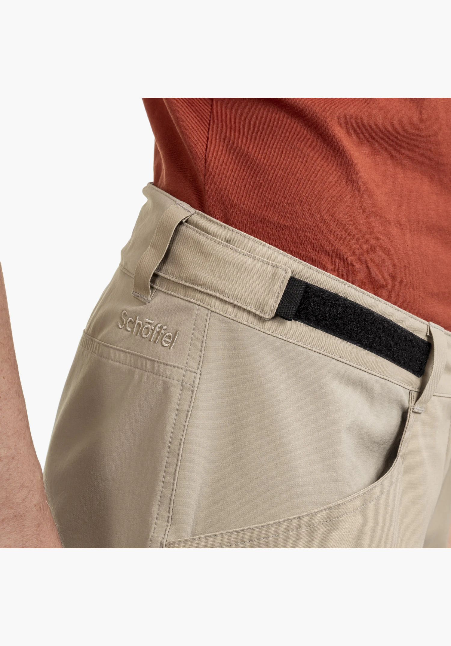 Shorts Style Maghera WMN montrant la taille réglable avec une bande auto-agrippante noire et le logo Schöffel brodé sur le tissu beige, gros plan sur fond blanc/neutre.