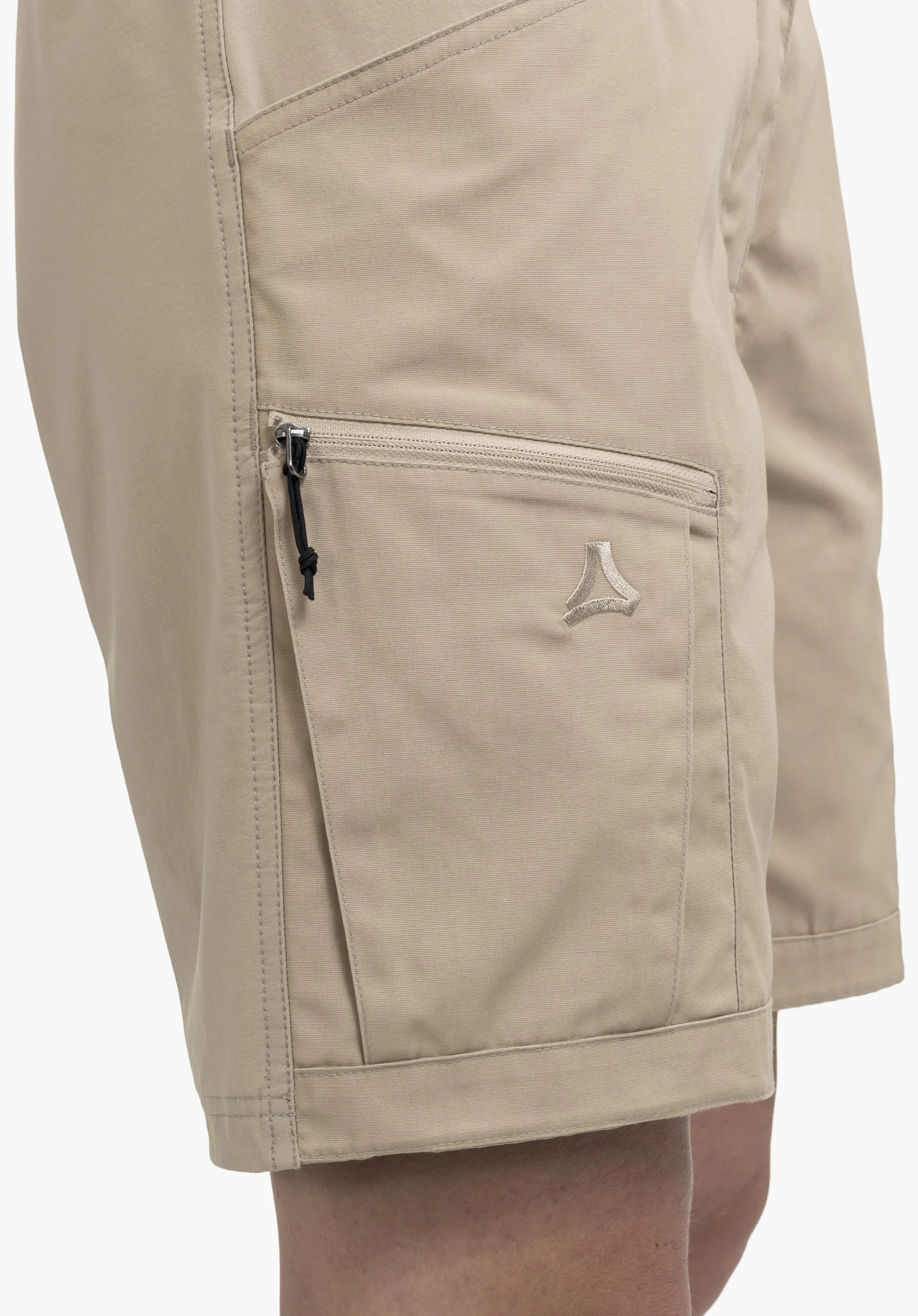 Shorts Style Maghera WMN, vue détaillée de la poche zippée sur la jambe beige avec une tirette noire et le Schöffel-Logo brodé, gros plan sur fond blanc/neutre.