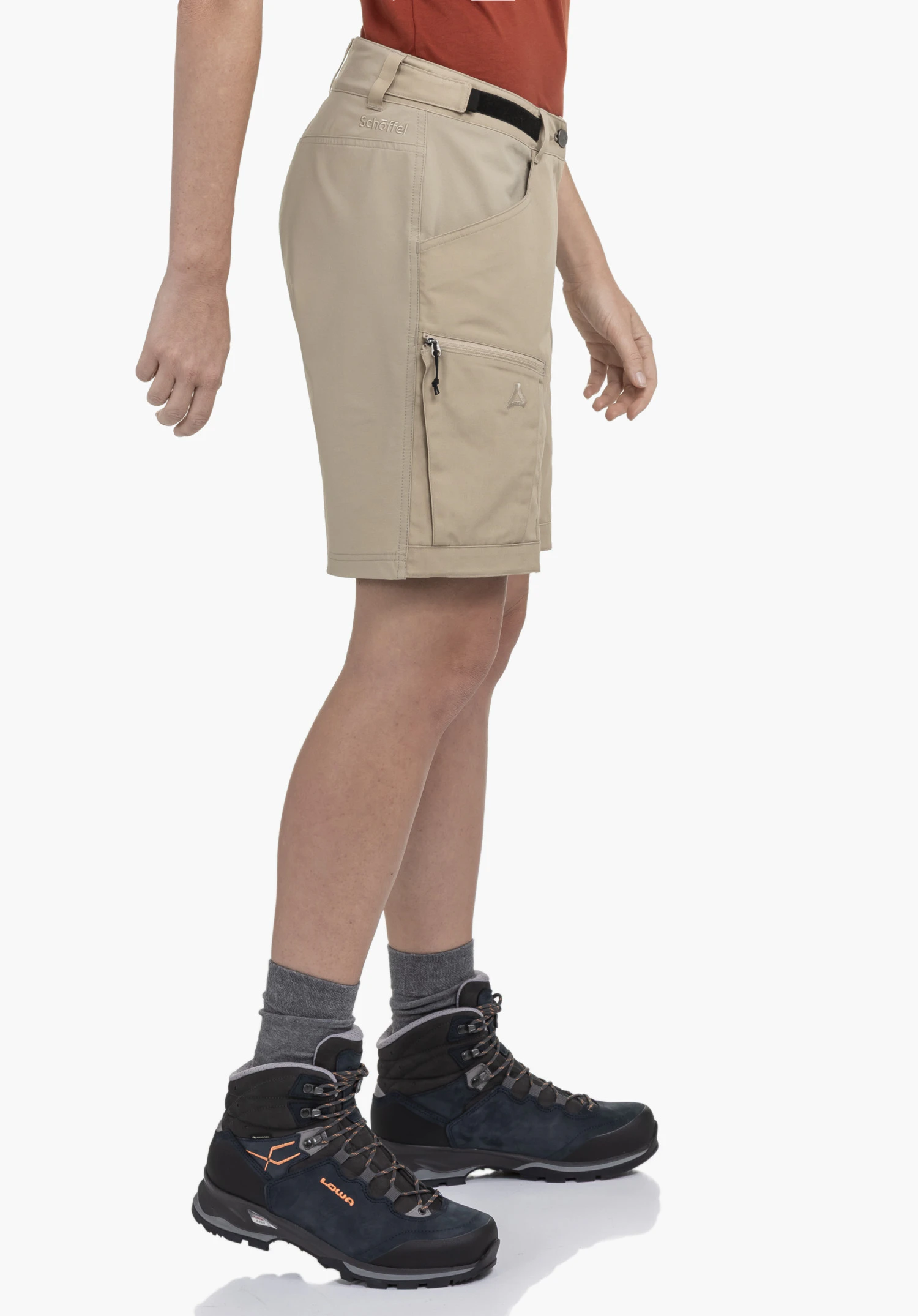 Shorts Style Maghera WMN en beige, porté par un mannequin debout de profil. On aperçoit la coupe, une poche latérale zippée et le logo Schöffel devant un fond neutre.