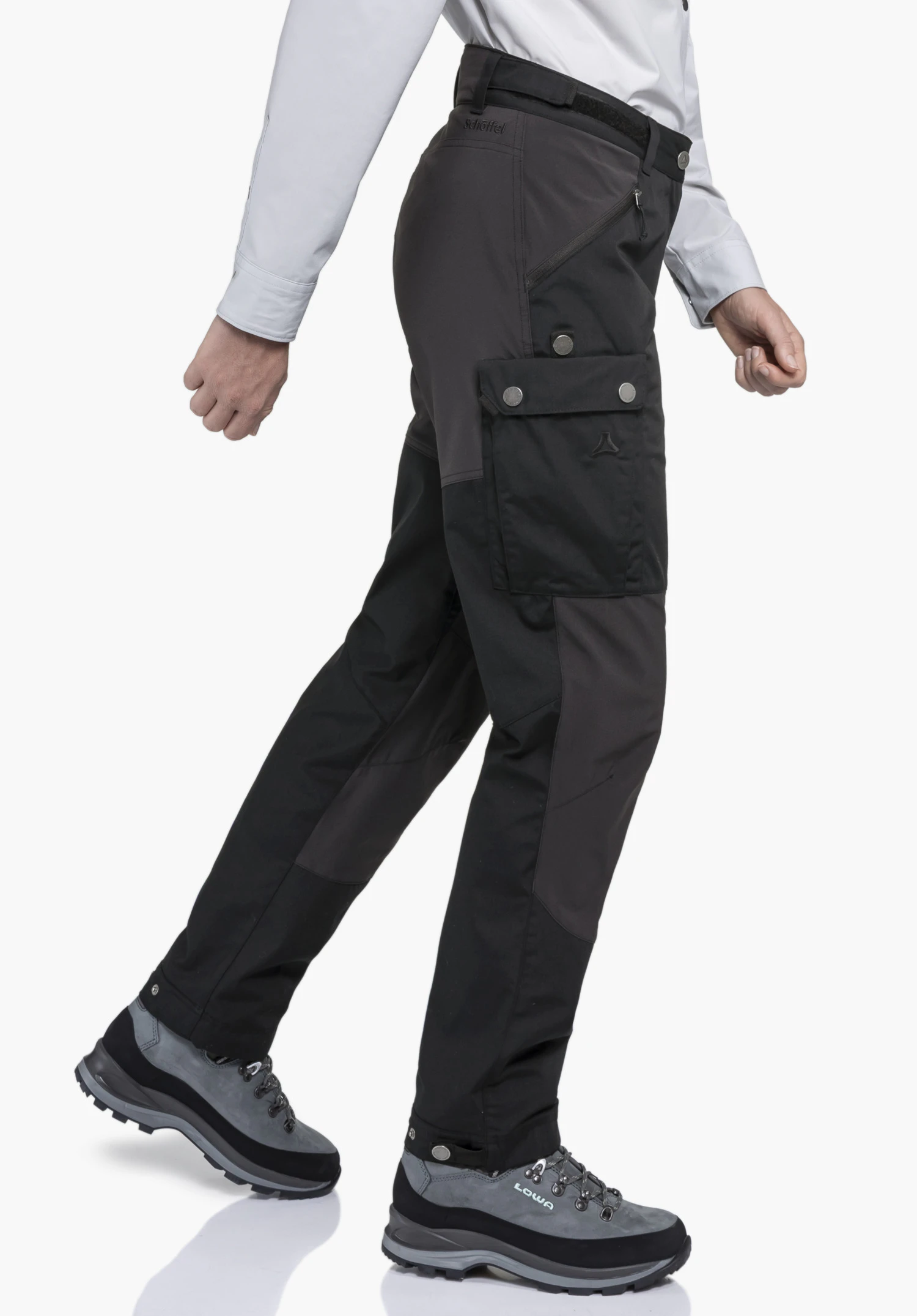 Pants Style Maghera WMN en noir. Le mannequin est photographié de profil sur un fond neutre, mettant en valeur le pantalon de randonnée en mouvement. Les poches pratiques et le discret logo Schöffel sur la cuisse sont bien visibles.