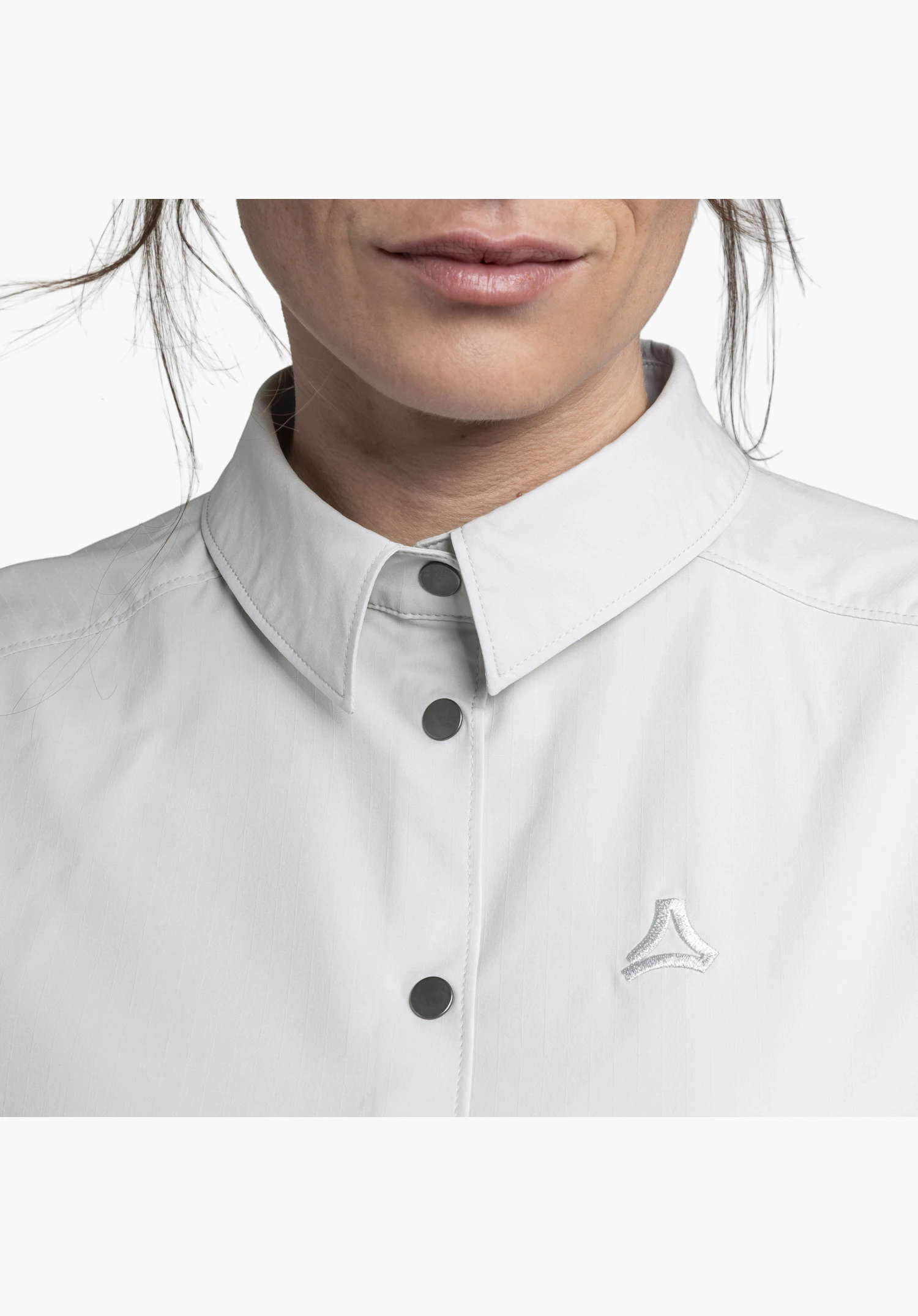 Blouse Style Maghera WMN en vue détaillée mettant en évidence le col classique, les boutons-pression foncés et le Schöffel-Logo brodé sur le tissu gris. Gros plan sur fond blanc/neutre.