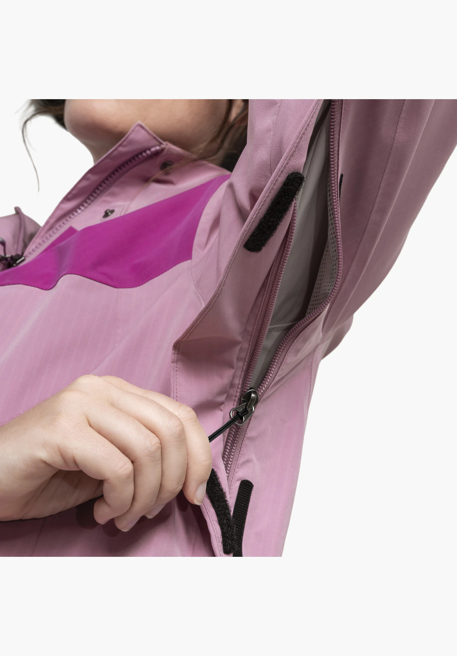 2L Jacket Style Maghera WMN in Rosa. Der Fokus liegt auf der geöffneten Unterarmbelüftung. Eine Hand zieht am Reißverschluss, wodurch das Mesh-Gewebe im Inneren und die Klettverschlüsse an der Abdeckleiste sichtbar werden, Nahaufnahme vor weißem/neutralem Hintergrund.