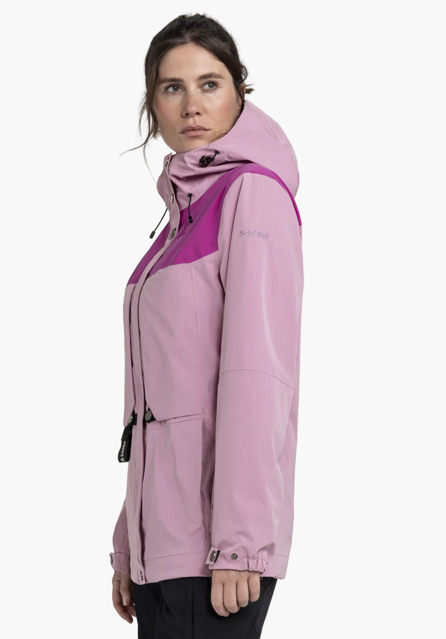 2L Jacket Style Maghera WMN in der Farbe Rosa. Das Model steht seitlich und trägt die Jacke, auf deren linkem Ärmel das Schöffel-Logo sichtbar ist. Die Aufnahme entstand vor einem neutralen Hintergrund.