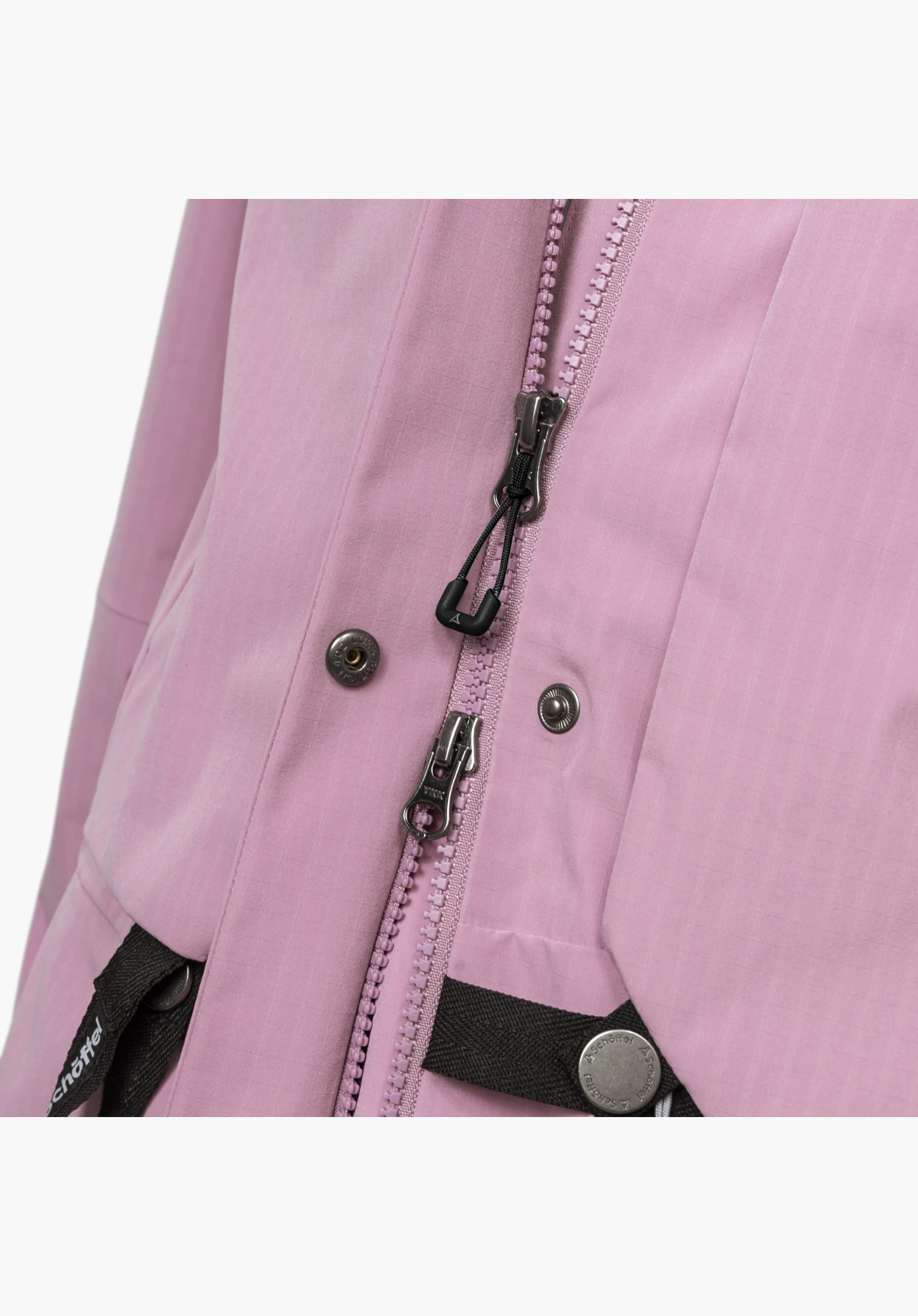 2L Jacket Style Maghera WMN zeigt einen robusten Zwei-Wege-Reißverschluss, metallische Druckknöpfe und fein strukturiertes, rosafarbenes Gewebe, ergänzt durch das Schöffel-Logo auf dem unteren Knopf und den schwarzen Kontrastbändern. Nahaufnahme vor weißem/neutralem Hintergrund.