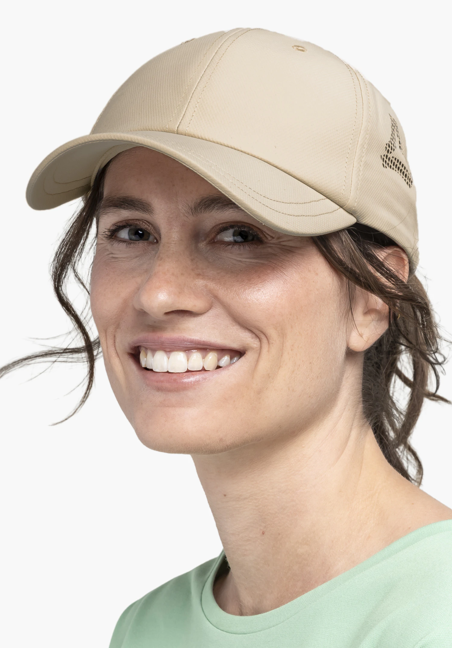 Cap Style Migandi WMN in Beige auf einer lächelnden Frau. Die Aufnahme zeigt die Frontalansicht vor einem neutralen Hintergrund, wobei das dezente Schöffel-Logo an der Seite des Caps gut erkennbar ist.