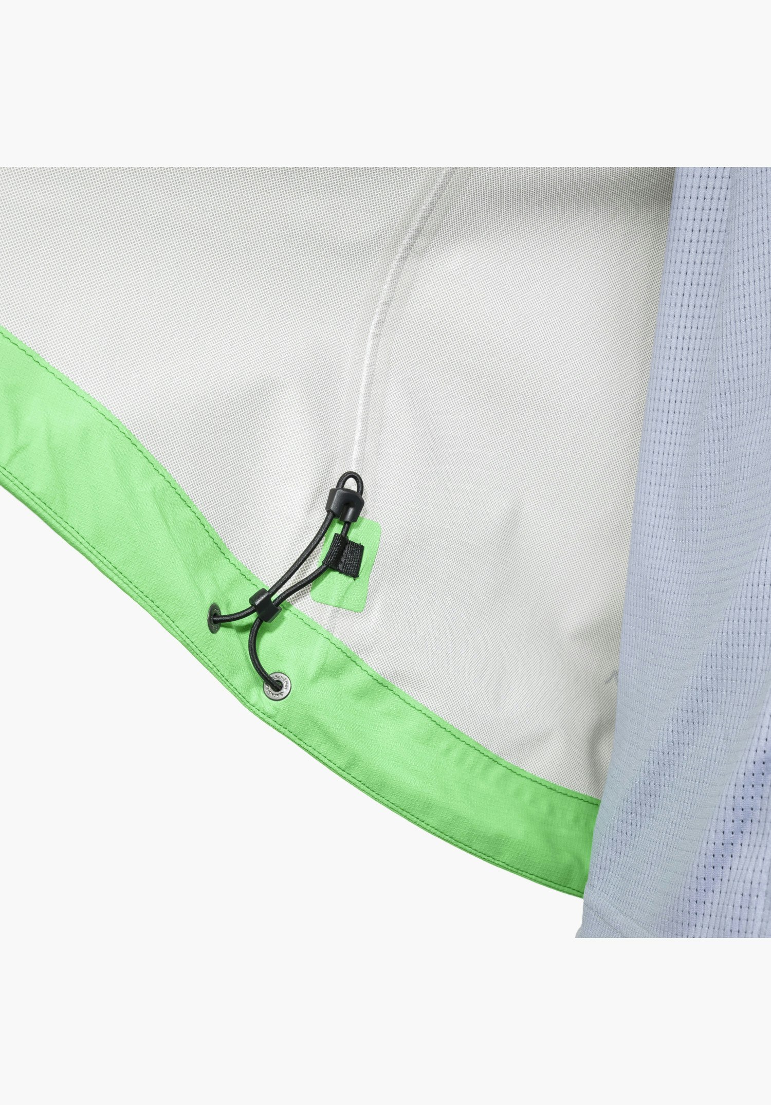 2.5L Jacket Style Tajiva WMN shows the adjustable drawcord system with toggle and a metal eyelet featuring a subtle Schöffel-Logo on the inner hem, contrasting in colour with the grey outer fabric, in a close-up against a white/neutral background.