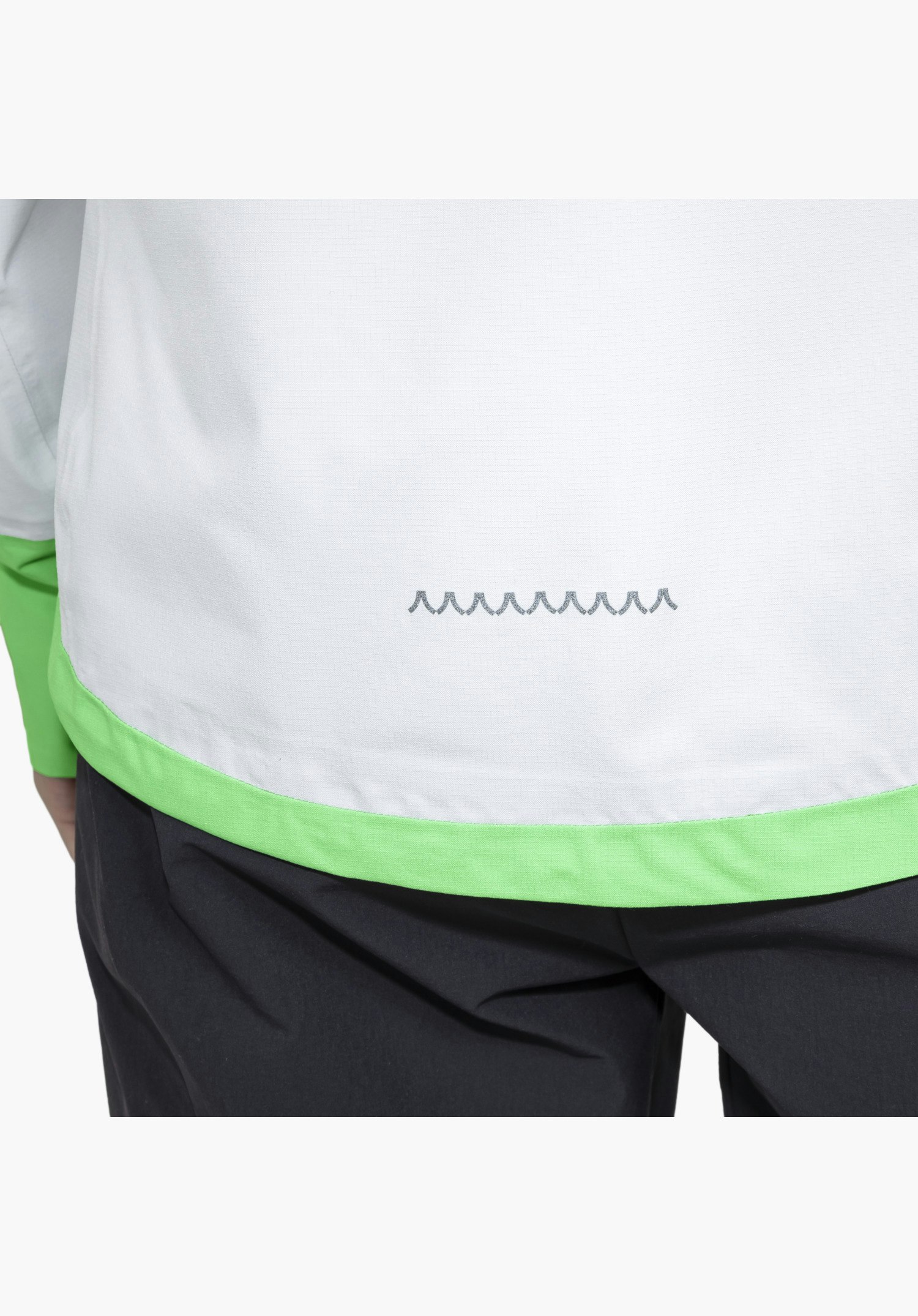 2.5L Jacket Style Tajiva WMN, detailed view of the light grey fabric at the lower back featuring a bright green hem and a printed dark grey mountain peak pattern, close-up against a white/neutral background.