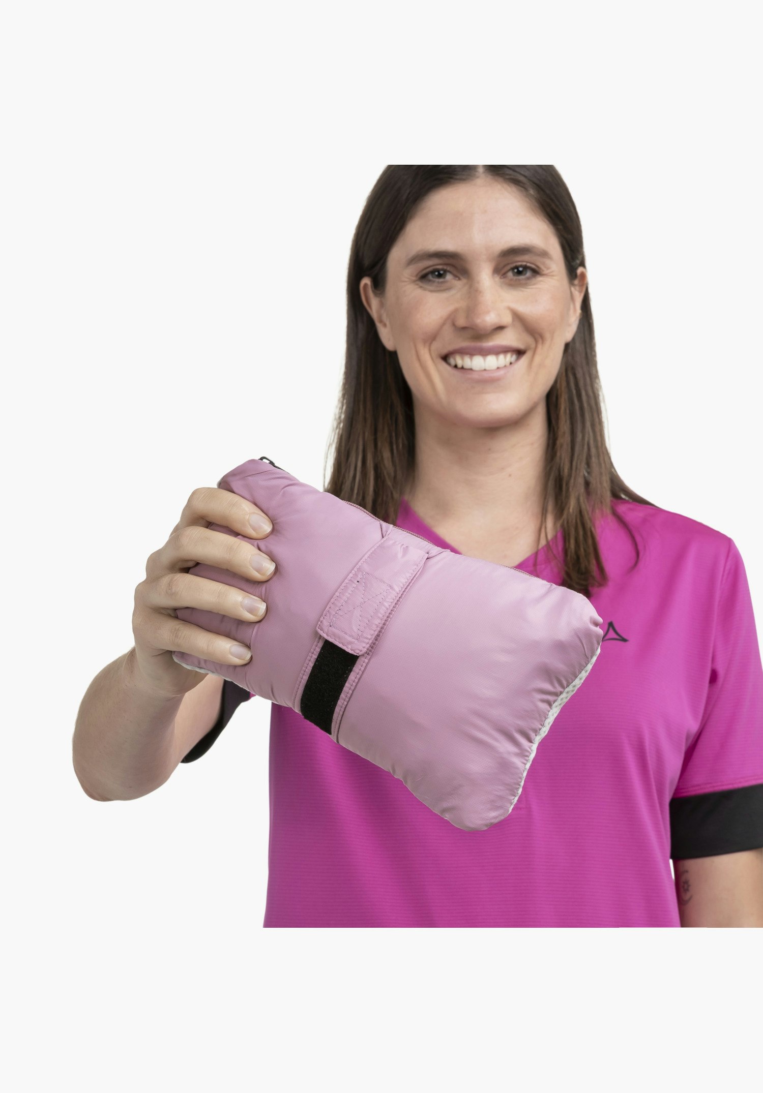 Ins Jacket Style Samaia WMN in der kompakten, rosafarbenen Pack-Away-Form mit schwarzem Klettverschlussriemen, in der Hand gehalten, Nahaufnahme vor weißem/neutralem Hintergrund.