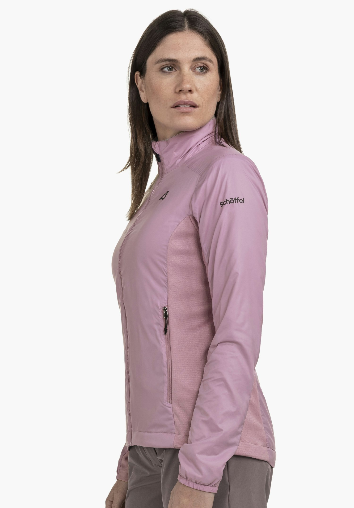 Ins Jacket Style Samaia WMN in zartem Rosa. Das Model steht seitlich vor einem neutralen Hintergrund und blickt zur Seite. Das schwarze Schöffel-Logo ist dezent am Oberarm platziert.