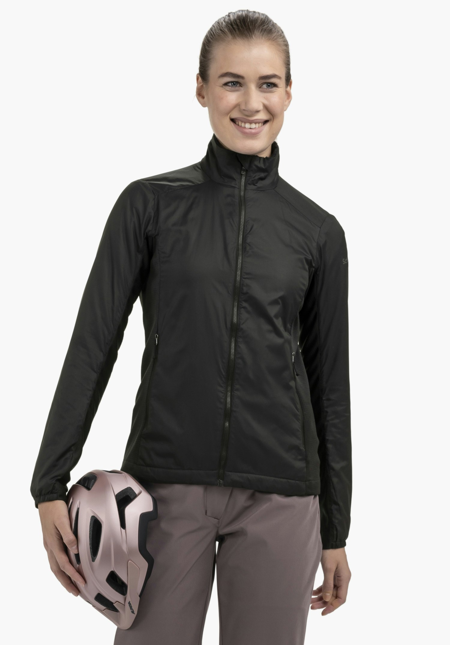 Ins Jacket Style Samaia WMN in black on a model. The woman stands facing the front and holds a bicycle helmet under her right arm, with the Schöffel logo visible on the left sleeve, presented against a neutral background.