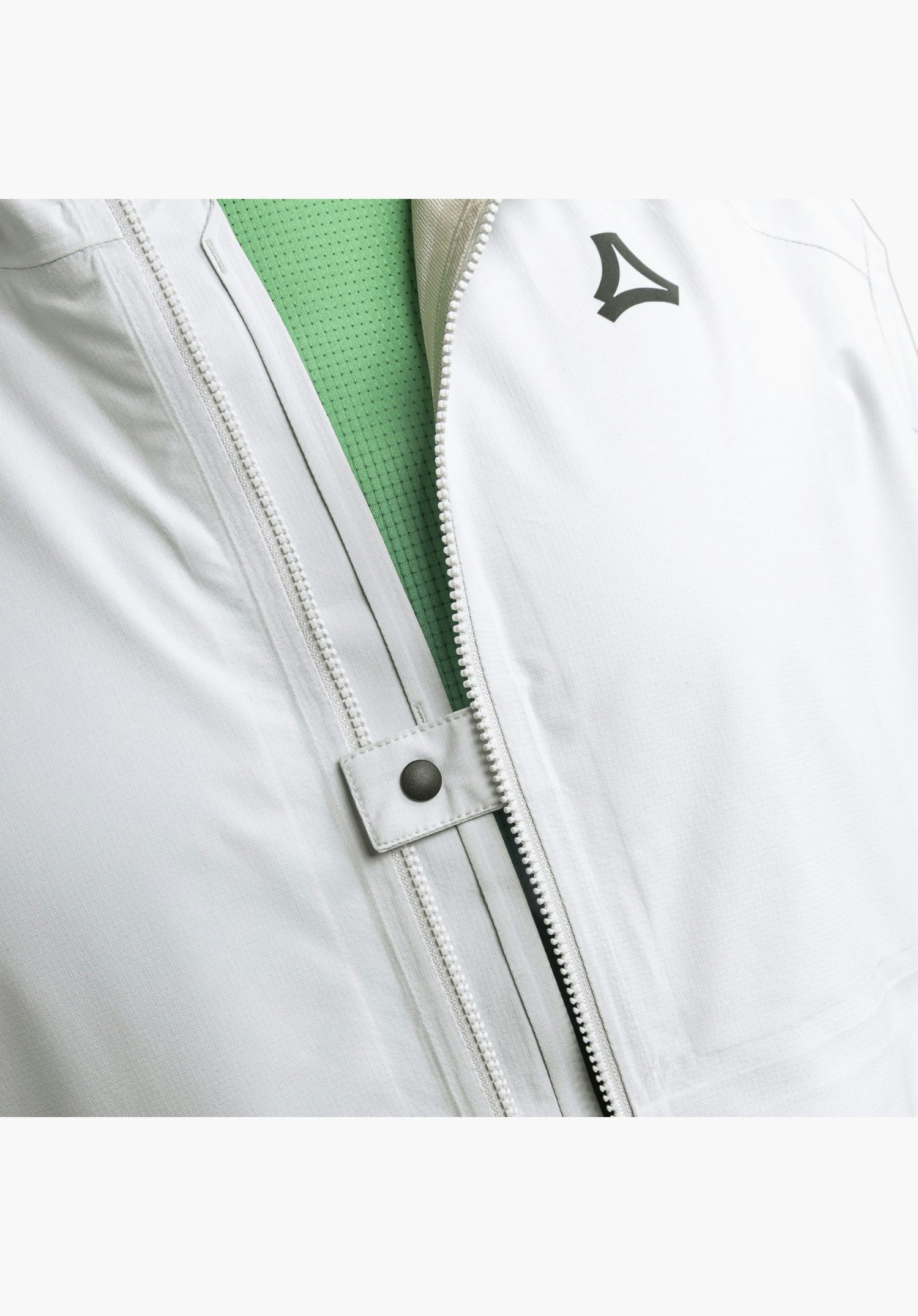 2.5L Jacket Style Tajiva MEN showing the partially open zip, a small fabric tab with a press stud, and the dark Schöffel-Logo on the grey fabric, while a green inner material is visible, close-up against a white/neutral background.