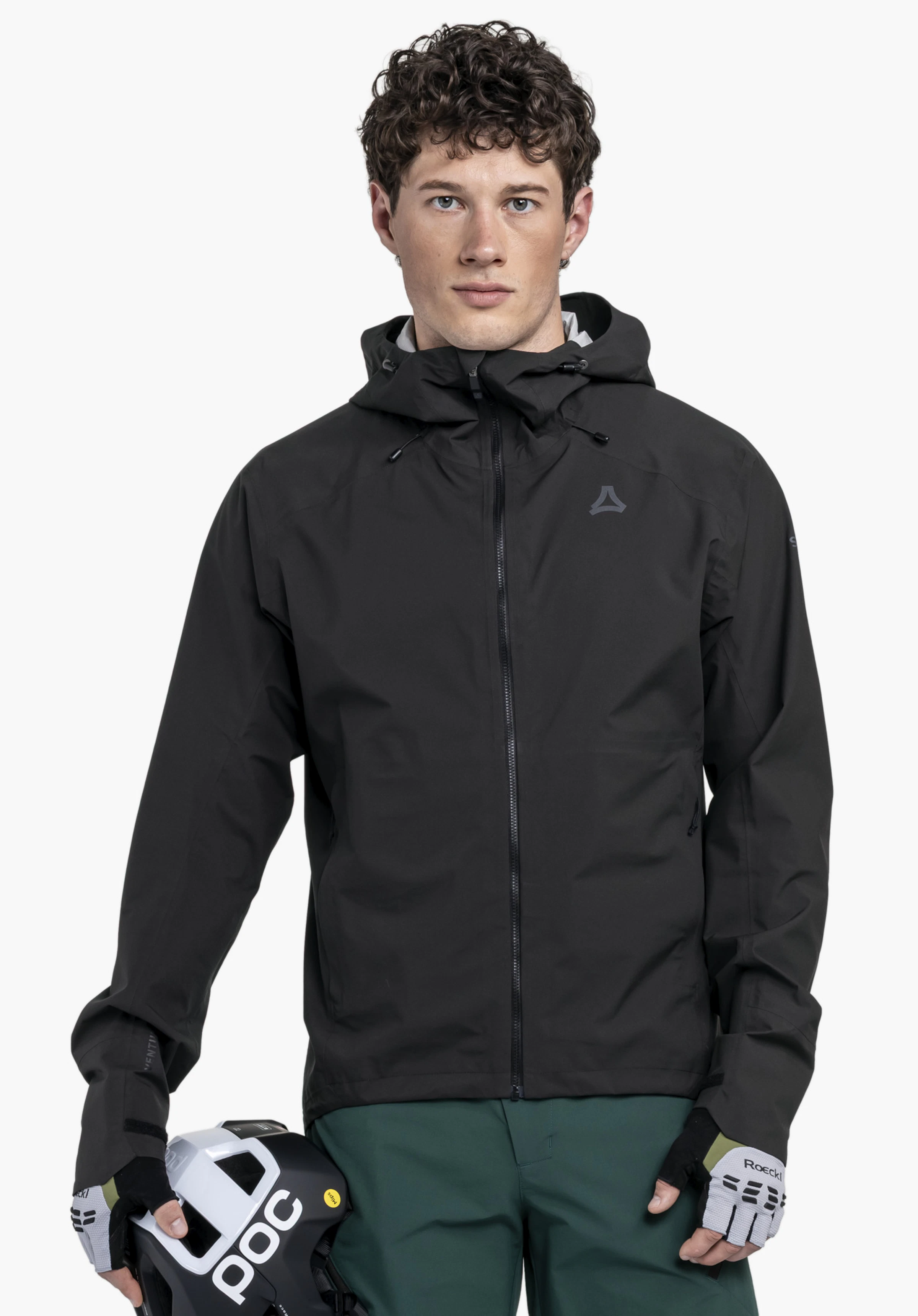 2.5L Jacket Style Tajiva MEN an einem Model, das frontal steht und einen Fahrradhelm hält. Er trägt die schwarze Jacke mit sichtbarem Schöffel-Logo auf der linken Brust vor einem neutralen Hintergrund.