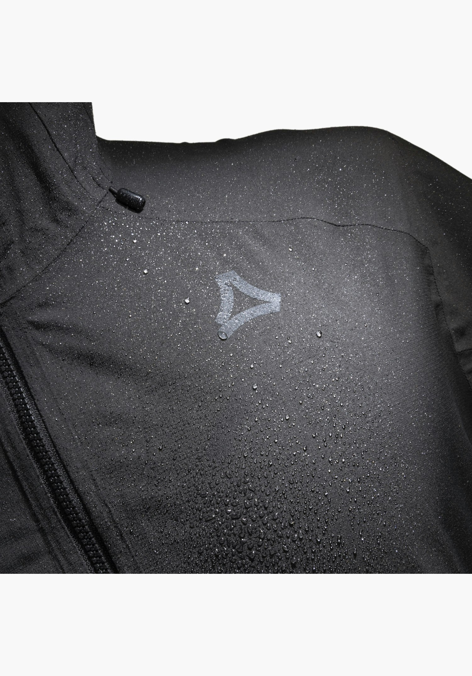 2.5L Jacket Style Tajiva MEN, schwarzer Stoff mit abperlenden Wassertropfen, dem Schöffel-Logo und einem angeschnittenen Reißverschluss als Nahaufnahme vor weißem Hintergrund.