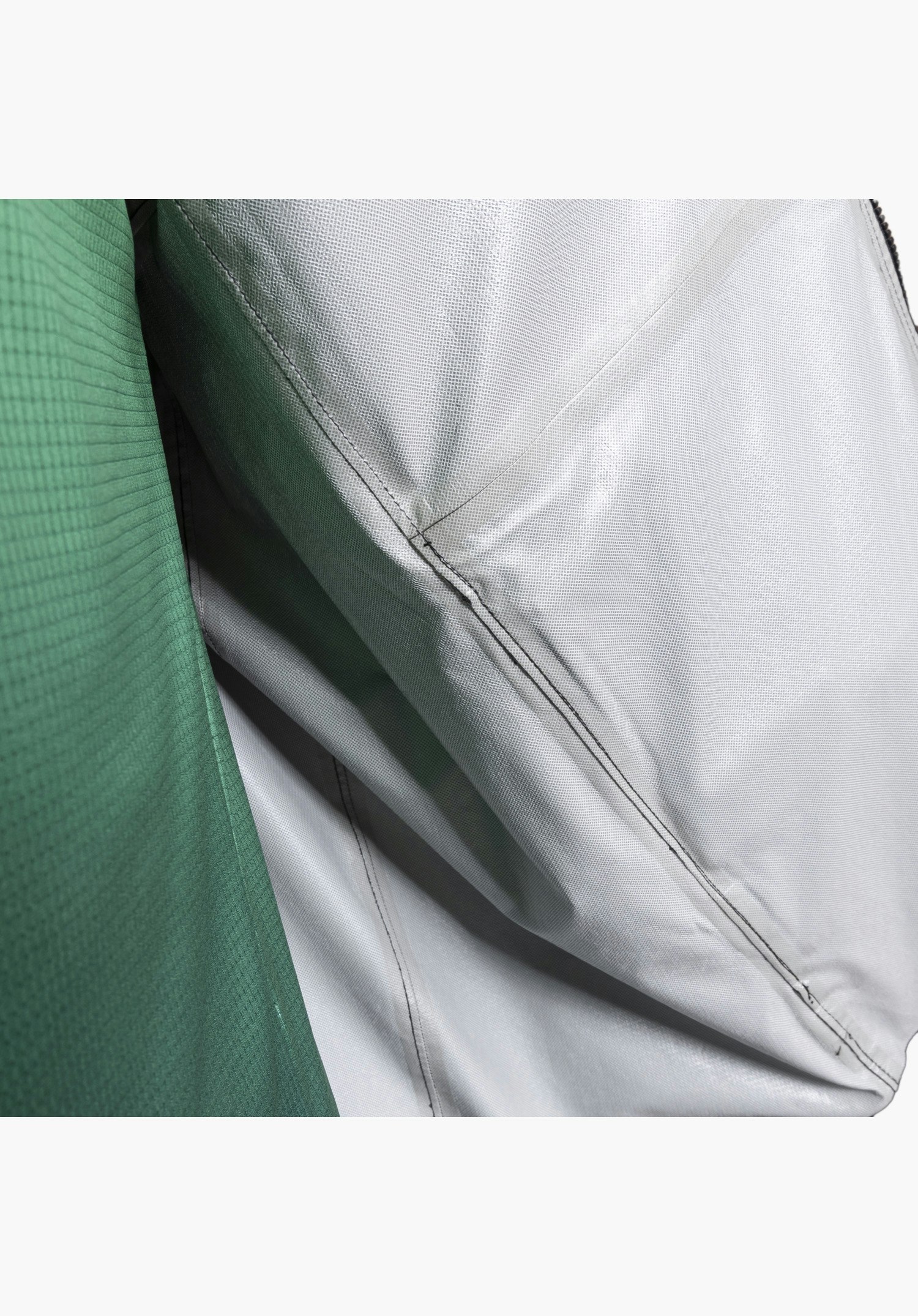 2.5L Jacket Style Tajiva MEN Detailansicht der Innenseite mit feiner technischer Struktur der 2,5-Lagen-Membran und auffällig versiegelten Nähten als wasserdichtes Design-Feature, kombiniert mit dem strukturierten Außenmaterial in Schwarz. Nahaufnahme vor weißem/neutralem Hintergrund.