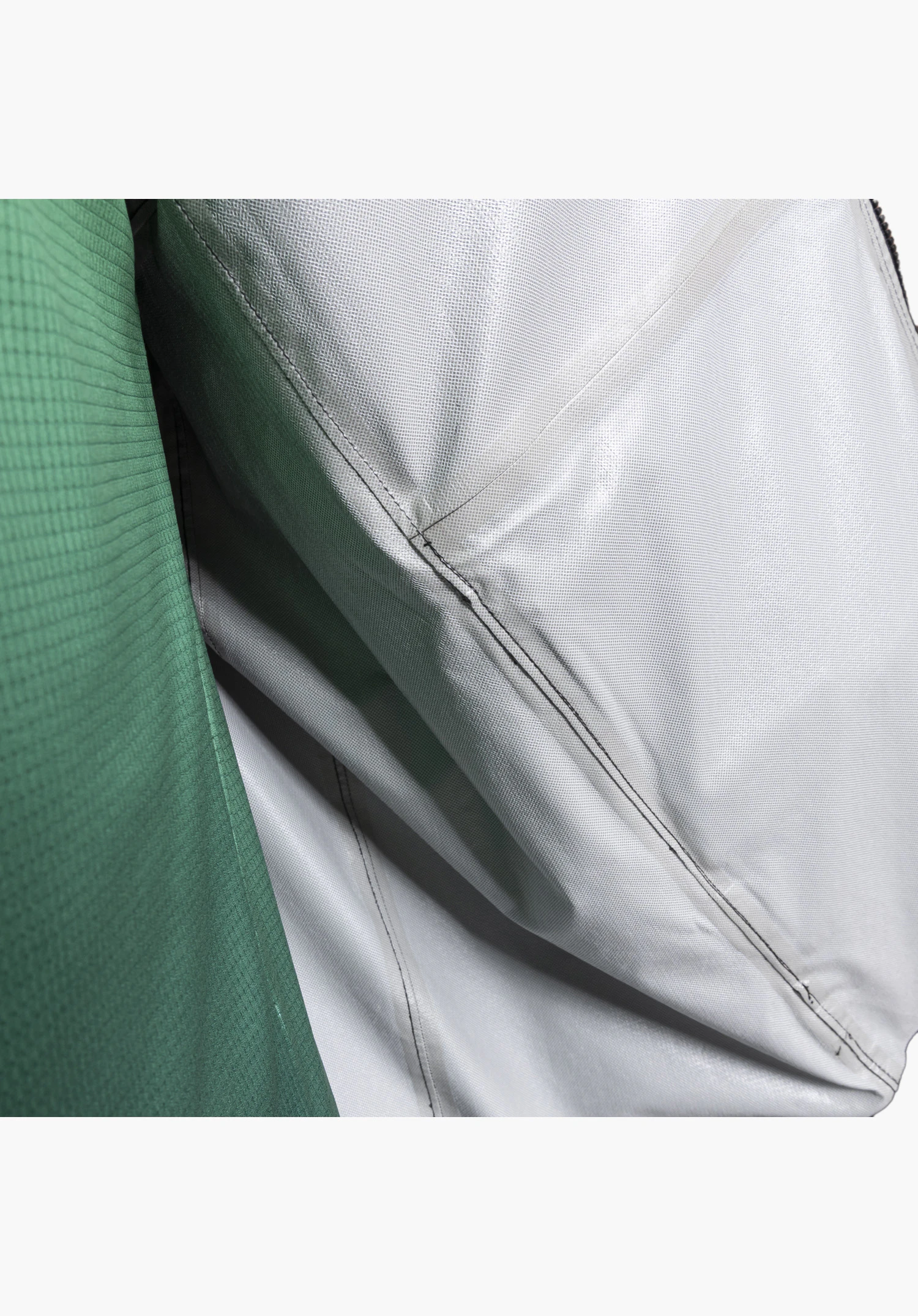 2.5L Jacket Style Tajiva MEN detailed view of the interior featuring the fine technical structure of the 2.5-layer membrane and prominently taped seams as a waterproof design feature, combined with the textured black outer fabric. Close-up against a white/neutral background.