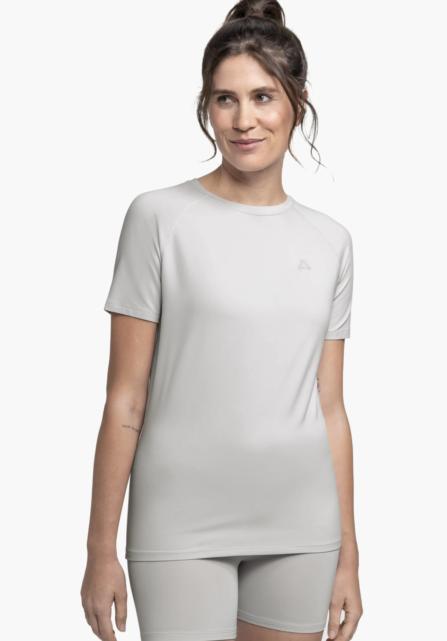 T Shirt Style Konera WMN bij een model dat frontaal staat, in de kleur grijs met een zichtbaar Schöffel-logo op de borst, voor een neutrale achtergrond.