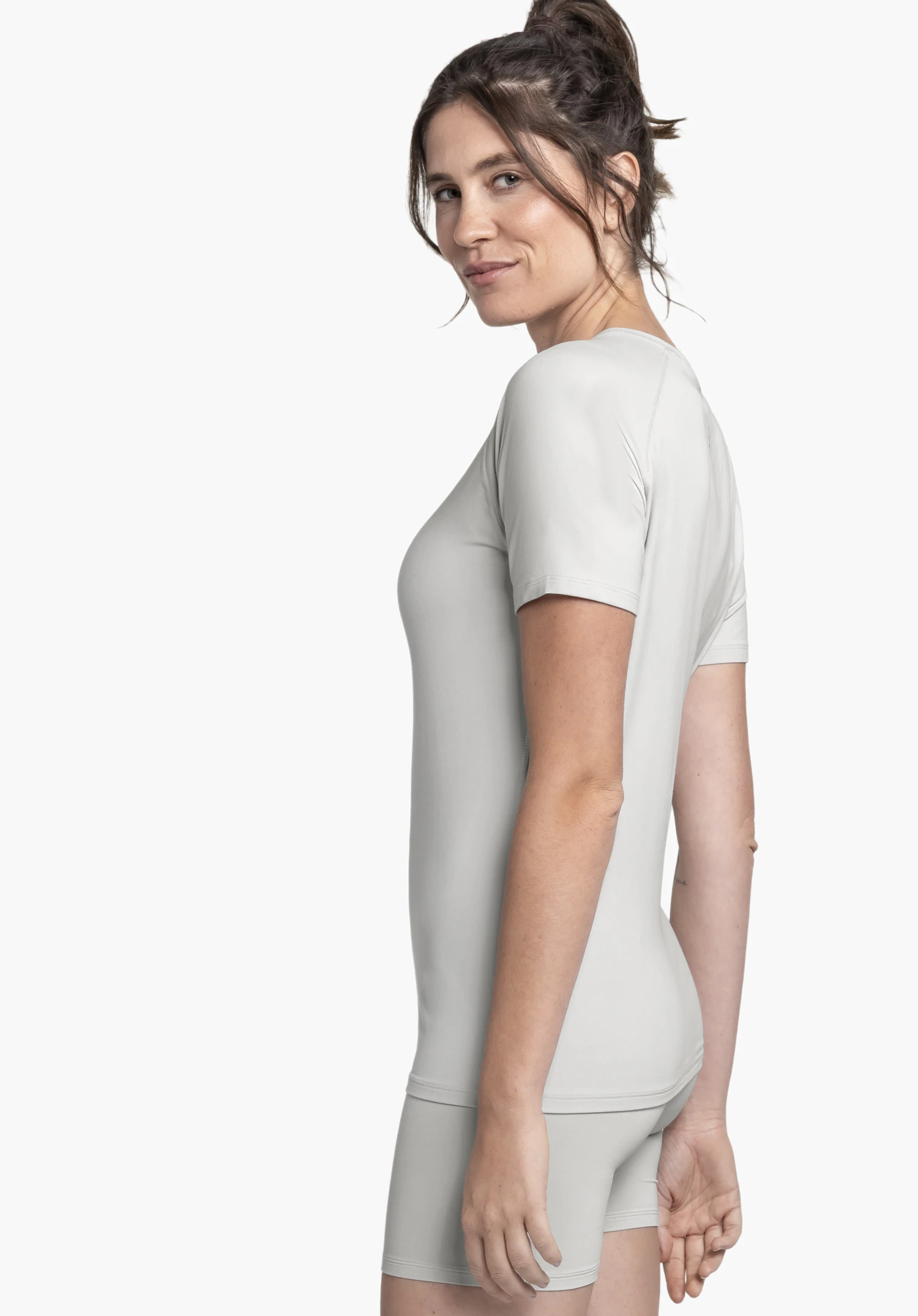 T Shirt Style Konera WMN en gris, présenté sur un fond neutre. Le mannequin pose de profil, mettant en valeur la coupe du t-shirt sous cet angle. Le discret logo Schöffel au niveau du col souligne le look épuré.