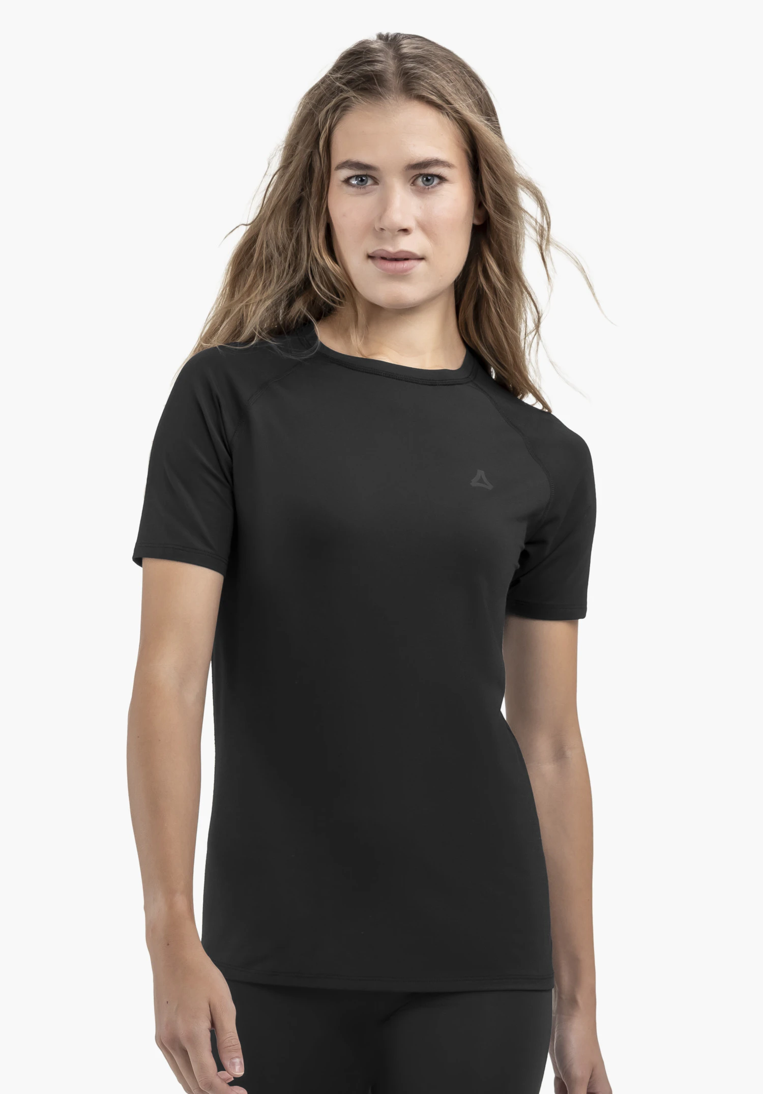 T Shirt Style Konera WMN op een model dat frontaal staat en in de camera kijkt. Het T-shirt in het zwart toont een subtiel Schöffel-logo op de linkerborst, gepresenteerd tegen een neutrale achtergrond.