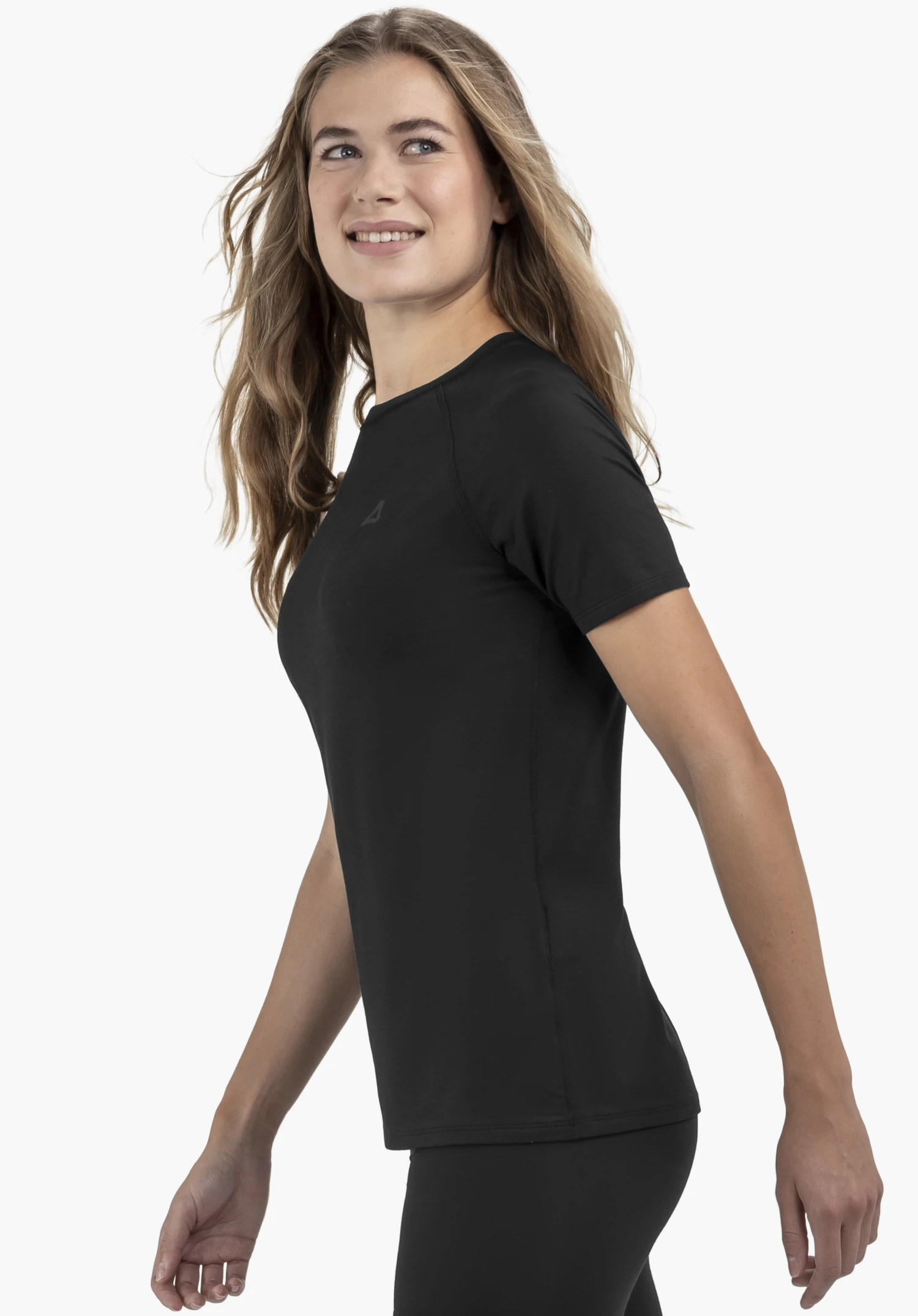 T Shirt Style Konera WMN en noir. Un mannequin photographié de profil sur un fond neutre. Le t-shirt séduit par son élégance sobre et le logo Schöffel discret au niveau de la poitrine.