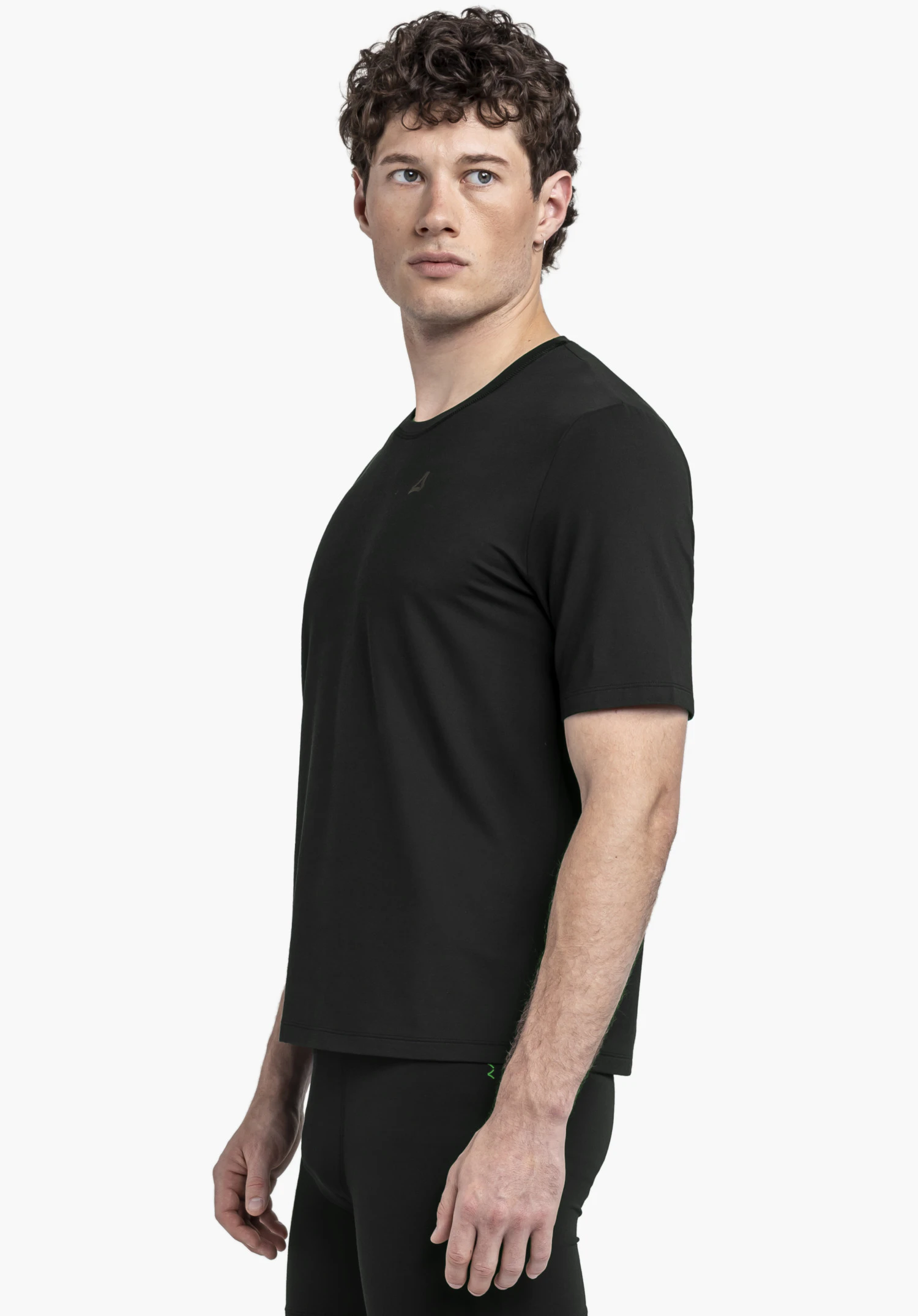 T Shirt Style Mafadi MEN in classic black. The model is standing in a side profile pose against a neutral background, highlighting the fit of the shirt. The Schöffel logo is subtly placed on the chest.