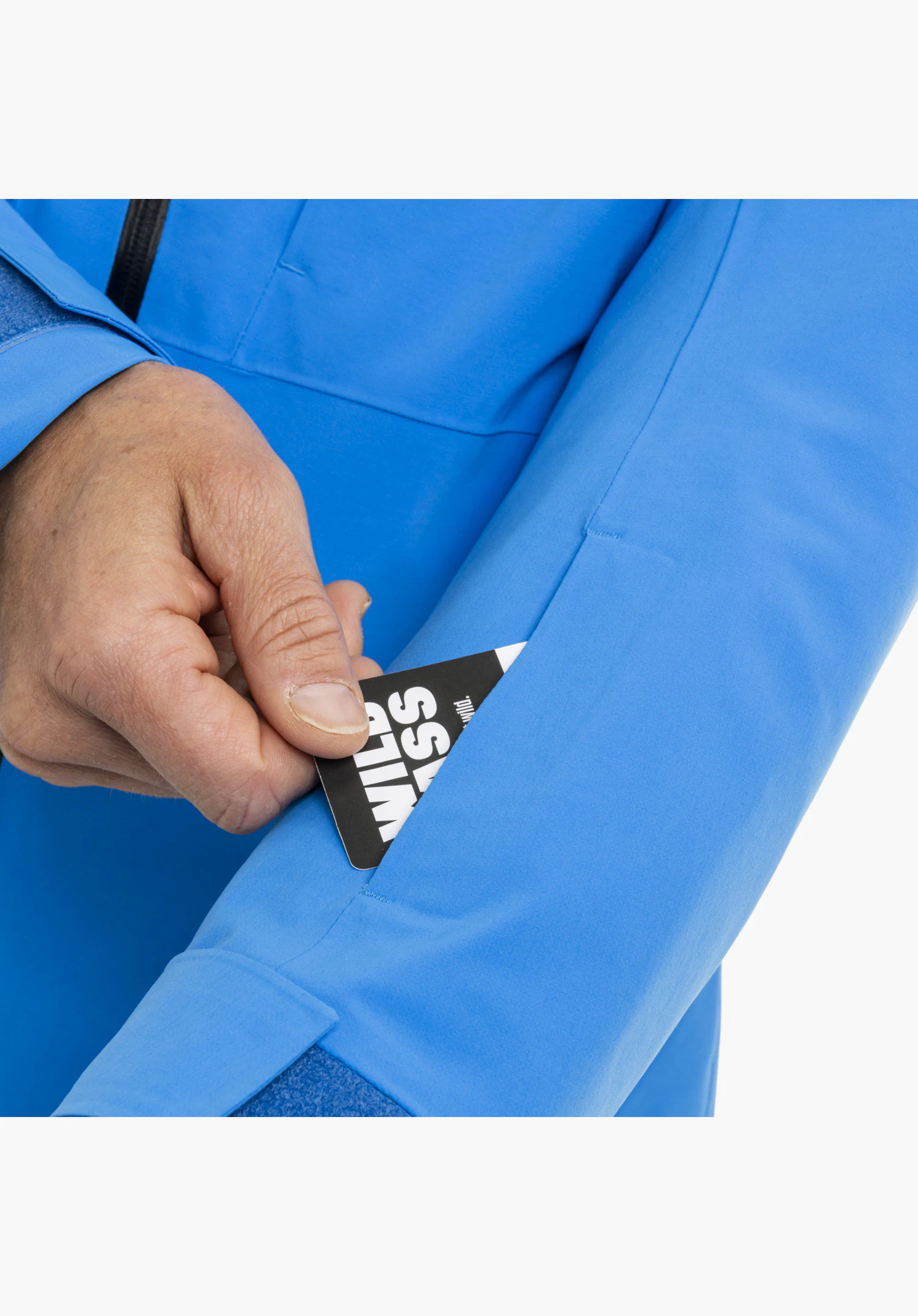 Jacket Style Pontre MEN in blue featuring a practical ski pass pocket on the sleeve holding a lift pass, close-up against a white background.